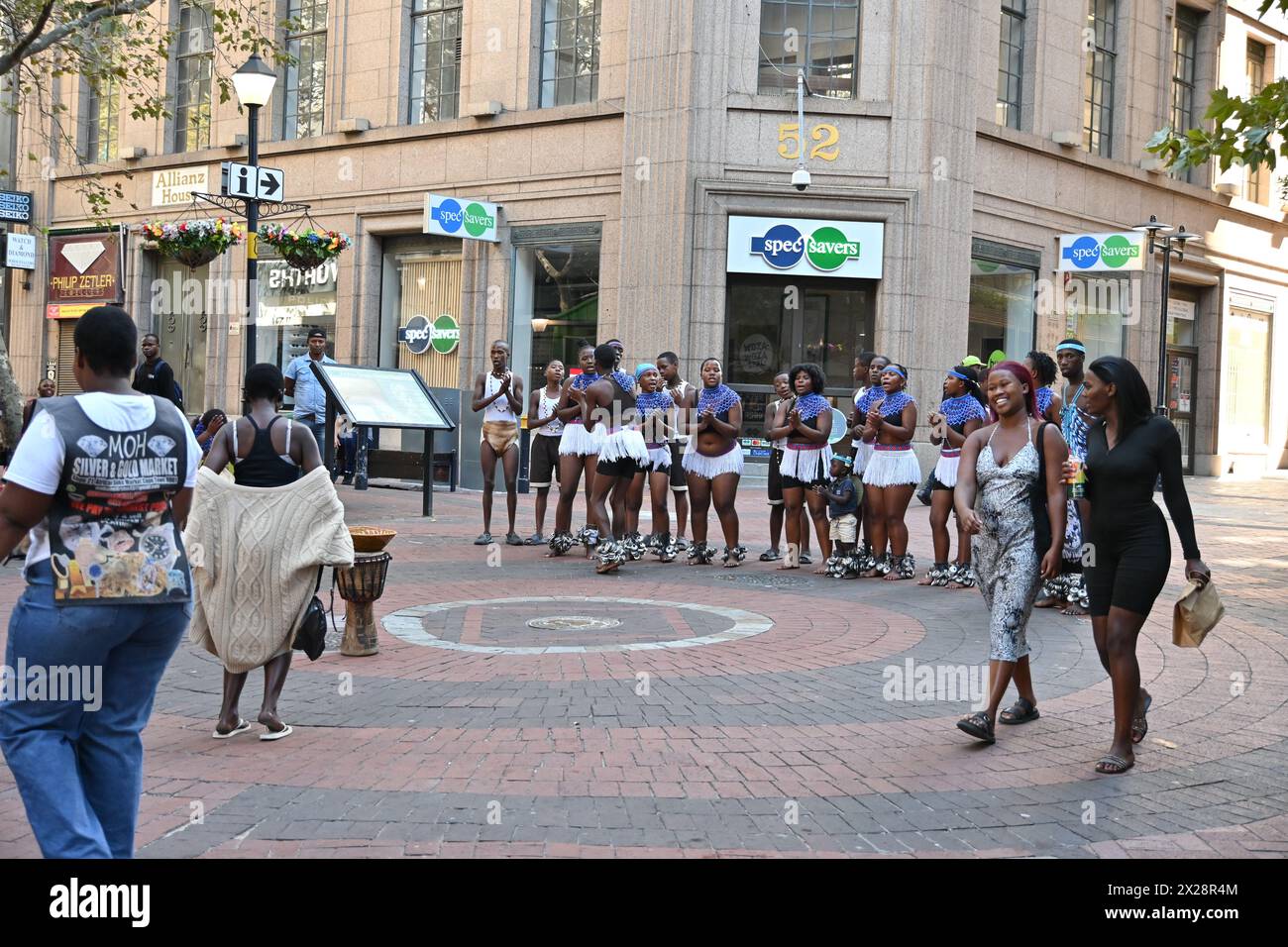 Gruppo di ragazzi e ragazze di colore in costume locale che eseguono una tipica danza africana nel centro di città del Capo, in Sudafrica Foto Stock