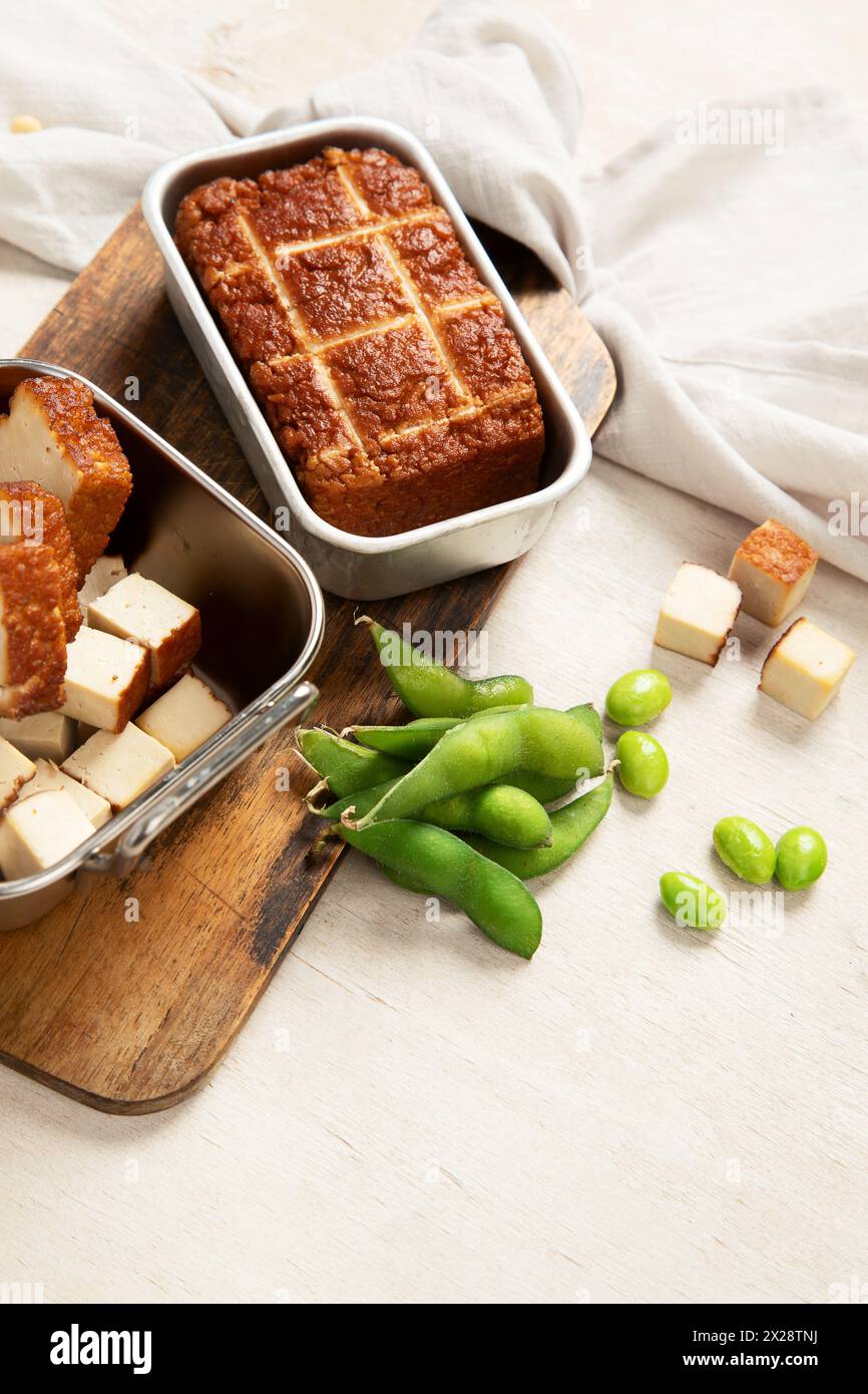 Cibo di soia. Tofu al forno su tavola, semi di soia. Prodotto vegano. Copia spazio Foto Stock