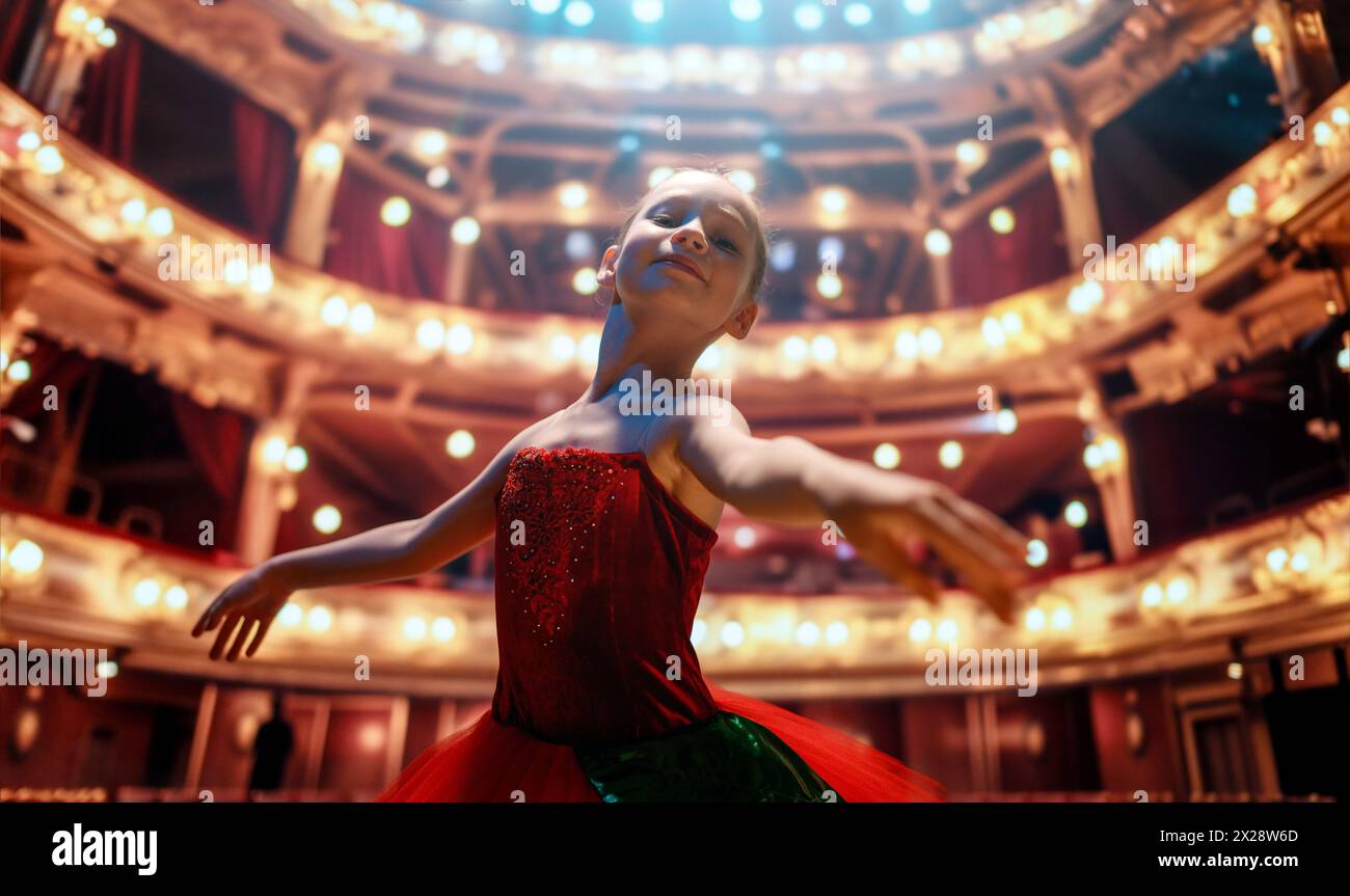 Una bambina carina che sogna di diventare una ballerina. Bambina in un tutu rosso che danza sul palco. Foto Stock