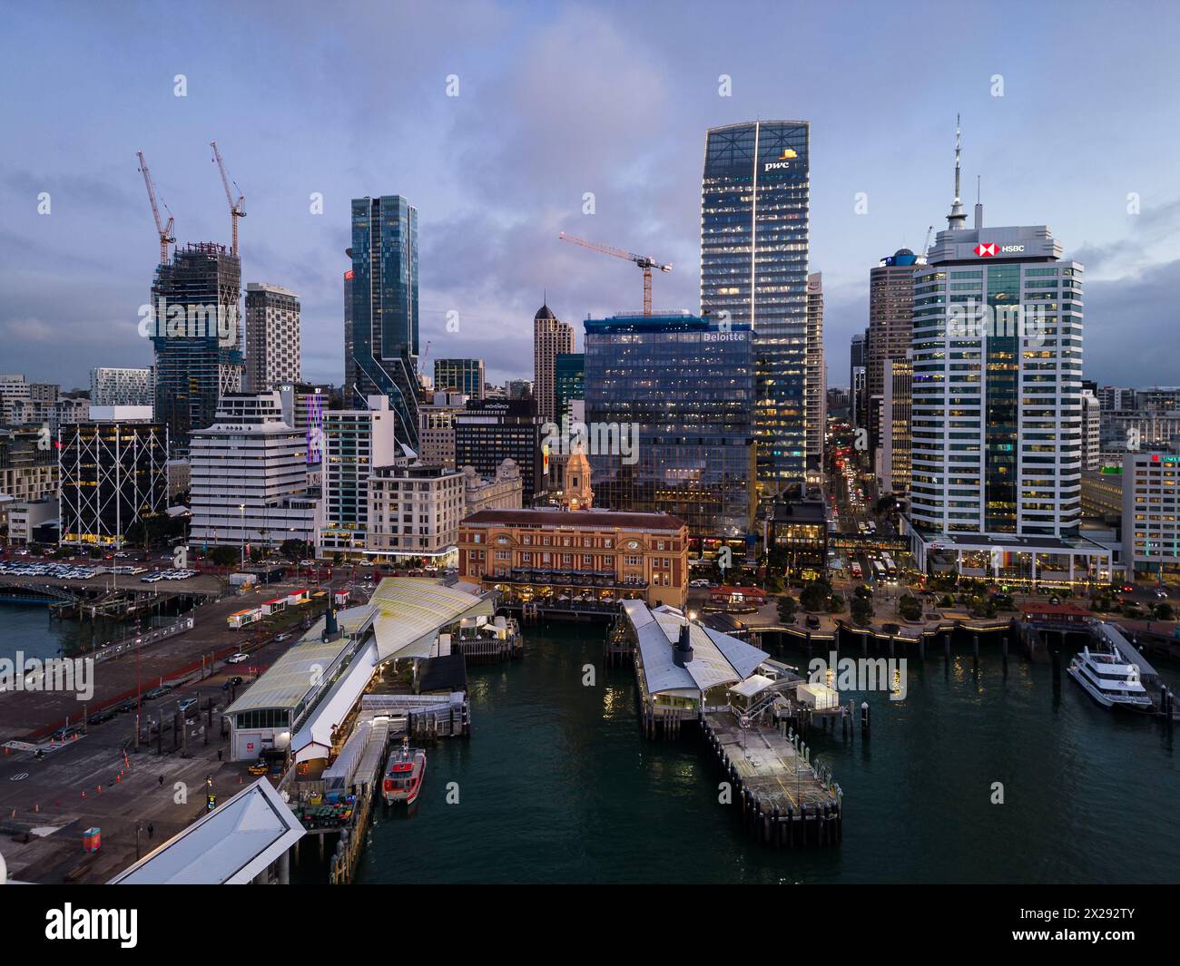 Auckland, nuova Zelanda - 24 luglio 2023: Spettacolare tramonto aereo sullo skyline del quartiere centrale degli affari di Auckland, sul terminal dei traghetti e sul Queens Wharf i. Foto Stock