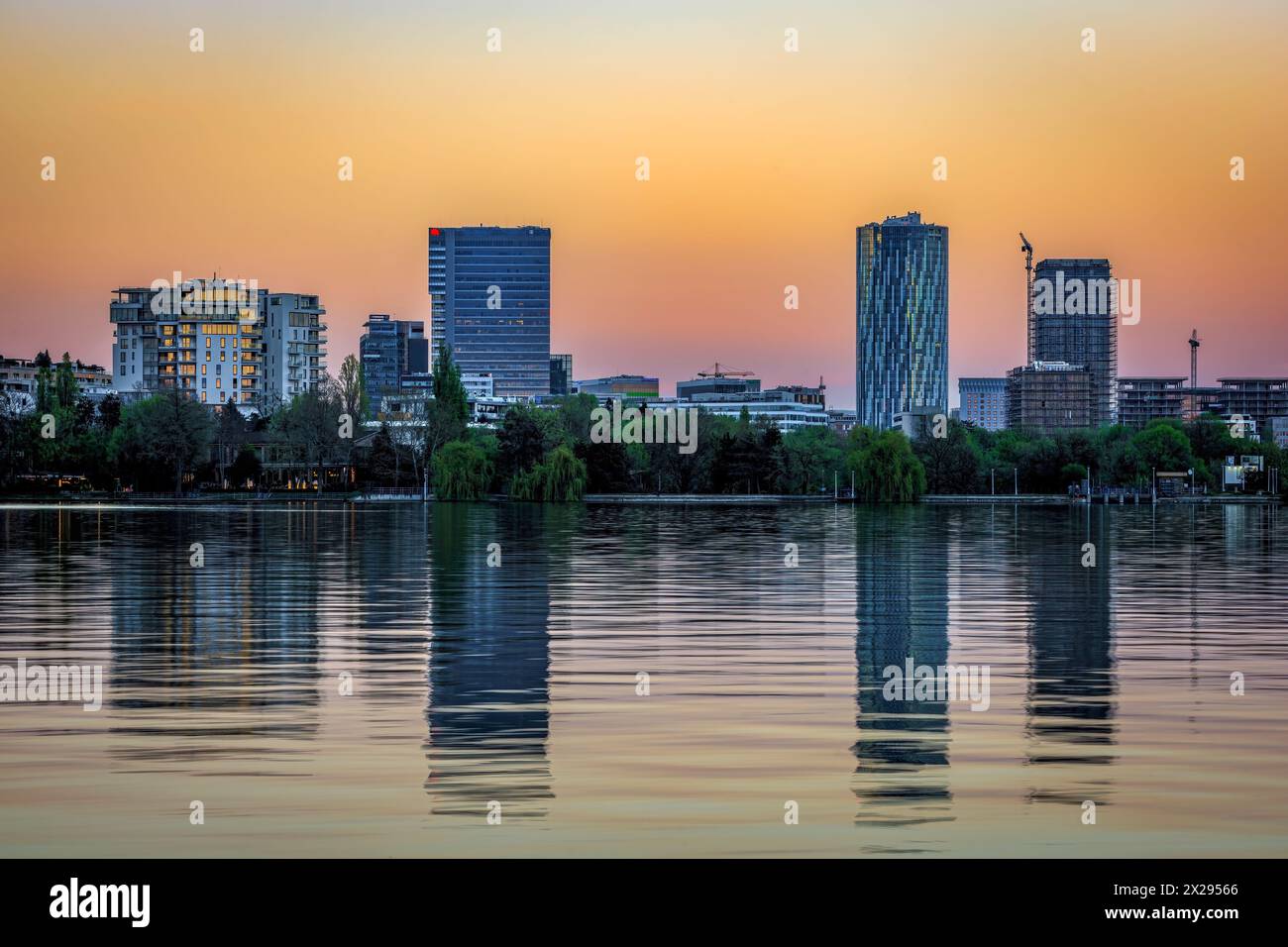 Lo skyline di Bucarest e il parco del lago Herastrau al crepuscolo. Foto scattata il 5 aprile 2024 a Bucarest, Romania. Foto Stock