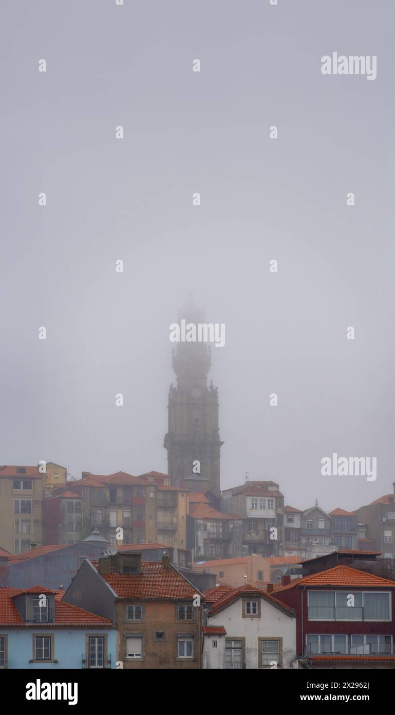 Chiesa dei Chierici, barocca del XVII secolo, che spicca tra le case e i tetti del quartiere storico di Porto, ricoperto da nebbia e Foto Stock