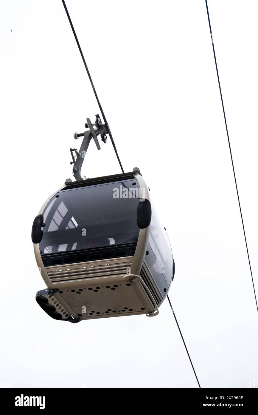 Vista dal basso di una funivia Vila Nova de Gaia sospesa su un cavo d'acciaio sotto un cielo bianco nuvoloso a Porto. Foto Stock