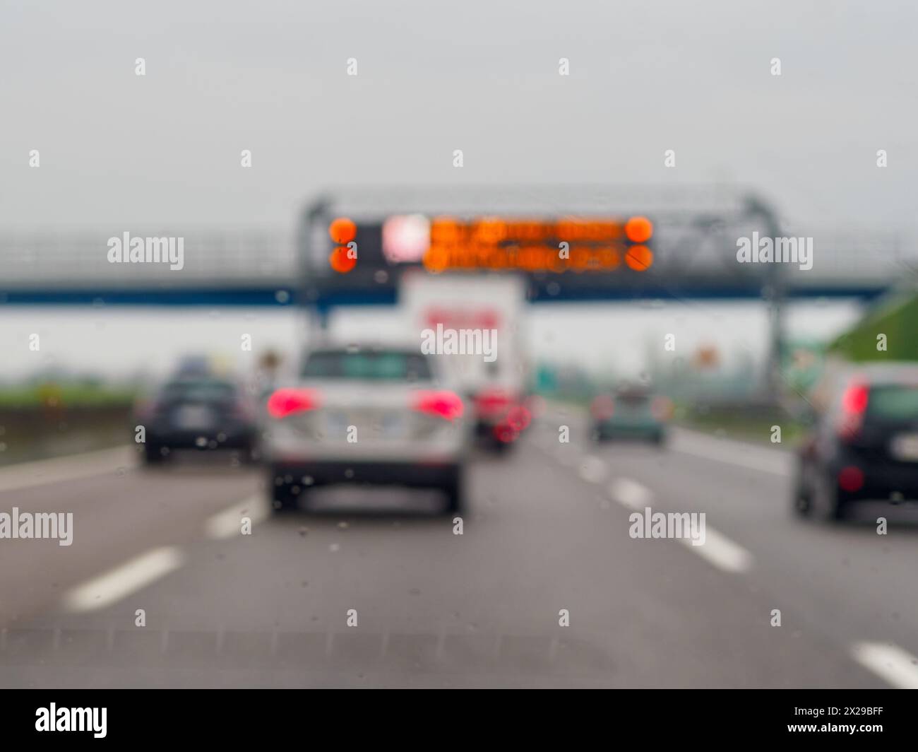 Immagine sfocata di un'autostrada trafficata con auto e camion. Le auto si muovono a un ritmo lento e il veicolo è in mezzo alla strada Foto Stock
