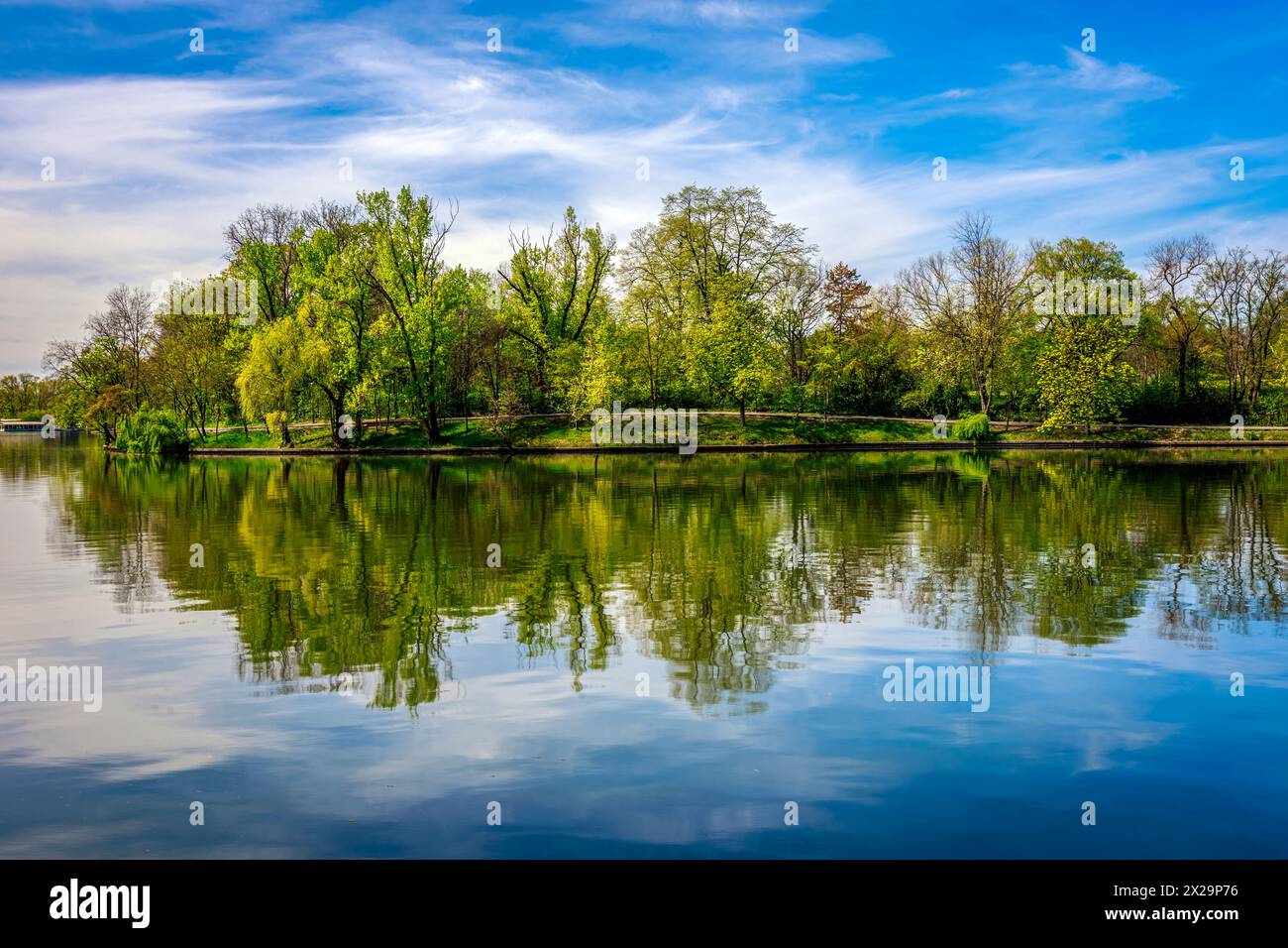 Il parco di Herastrau e l'isola si specchiano nell'acqua. Foto scattata il 5 aprile 2024 a Bucarest, Romania. Foto Stock