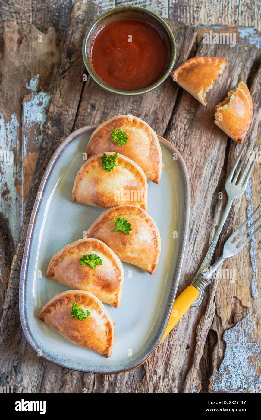 Empanadas argentine fresche fatte in casa servite con salsa al peperoncino Foto Stock