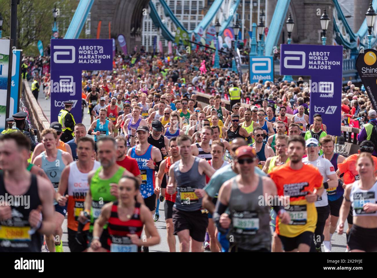 Tower Hill, Londra, Regno Unito. 21 aprile 2024. Circa 50.000 persone partecipano alla maratona TCS di Londra del 2024, tra cui i migliori runner e gli atleti in sedia a rotelle del mondo. Le masse di corridori del club e del divertimento li seguono, con molti che raccolgono grandi somme per beneficenza e spesso corrono in abiti eleganti e puntano al Guinness dei primati per varie classi. Massa di corridori che attraversano il Tower Bridge Foto Stock