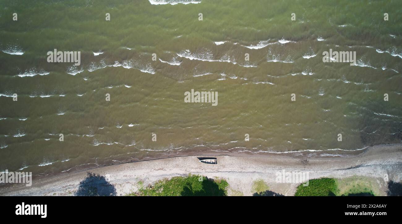 Piccola barca sulla riva del lago, vista dall'alto con drone aereo nelle giornate di sole Foto Stock