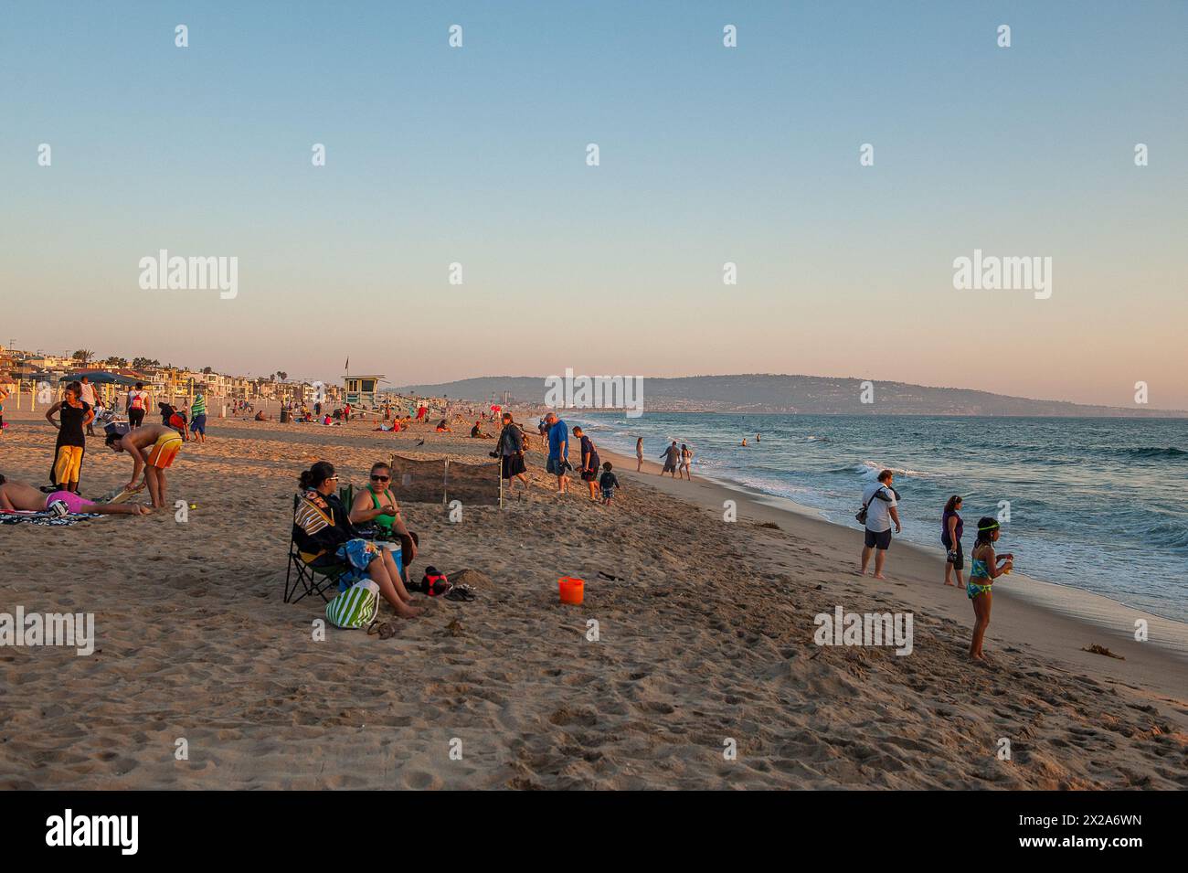 La gente si gode il tramonto sulla spiaggia di Manhattan sulla spiaggia della costa del pacifico nella zona di South Bay di Los Angeles, CA, USA Foto Stock