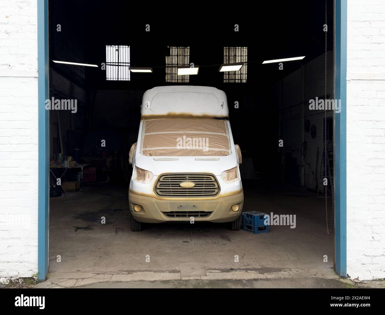 Pulmino in garage in fase di ristrutturazione e verniciatura a spruzzo Foto Stock