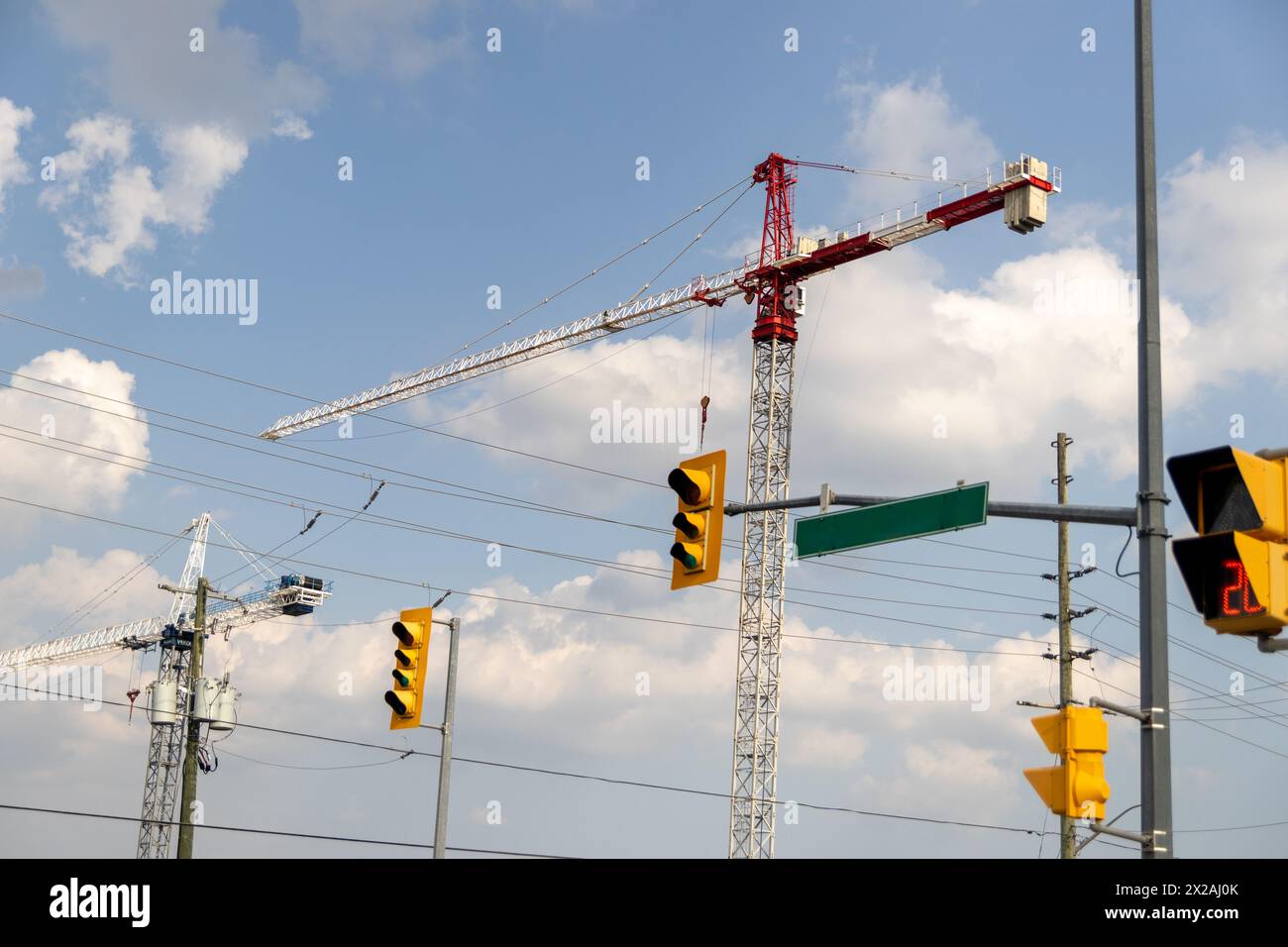 Gru a torre rosse e bianche - cielo con soffici nuvole - semafori e segnali stradali in primo piano. Presa a Toronto, Canada. Foto Stock