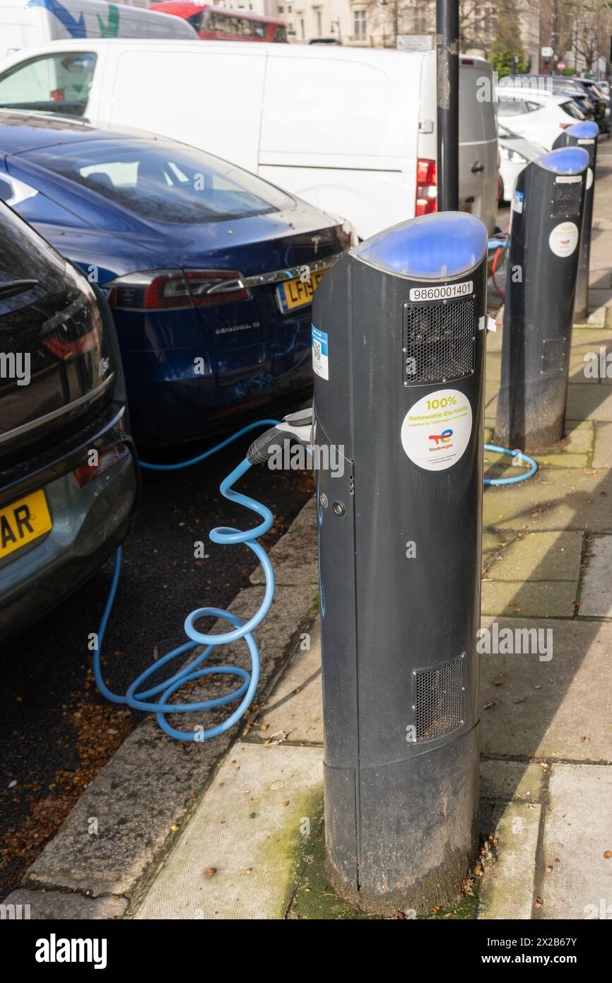 Auto elettriche - una BMW i3 e una Tesla collegate e caricate - presso una stazione di ricarica elettrica di rete pubblica fornita da Source London. Londra, Inghilterra Foto Stock