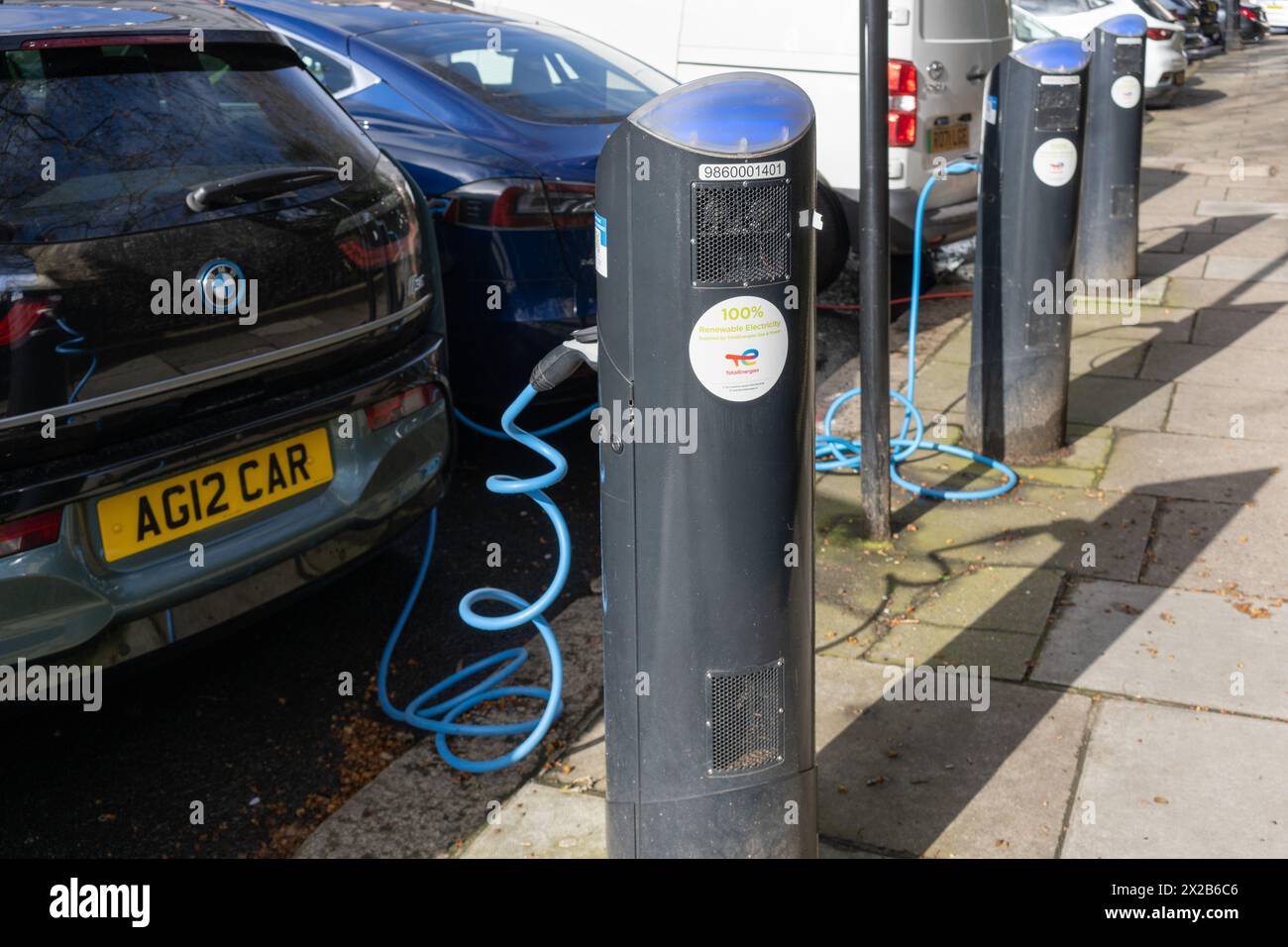 Auto elettriche - una BMW i3 e una Tesla collegate e caricate - presso una stazione di ricarica elettrica di rete pubblica fornita da Source London. Londra, Inghilterra Foto Stock