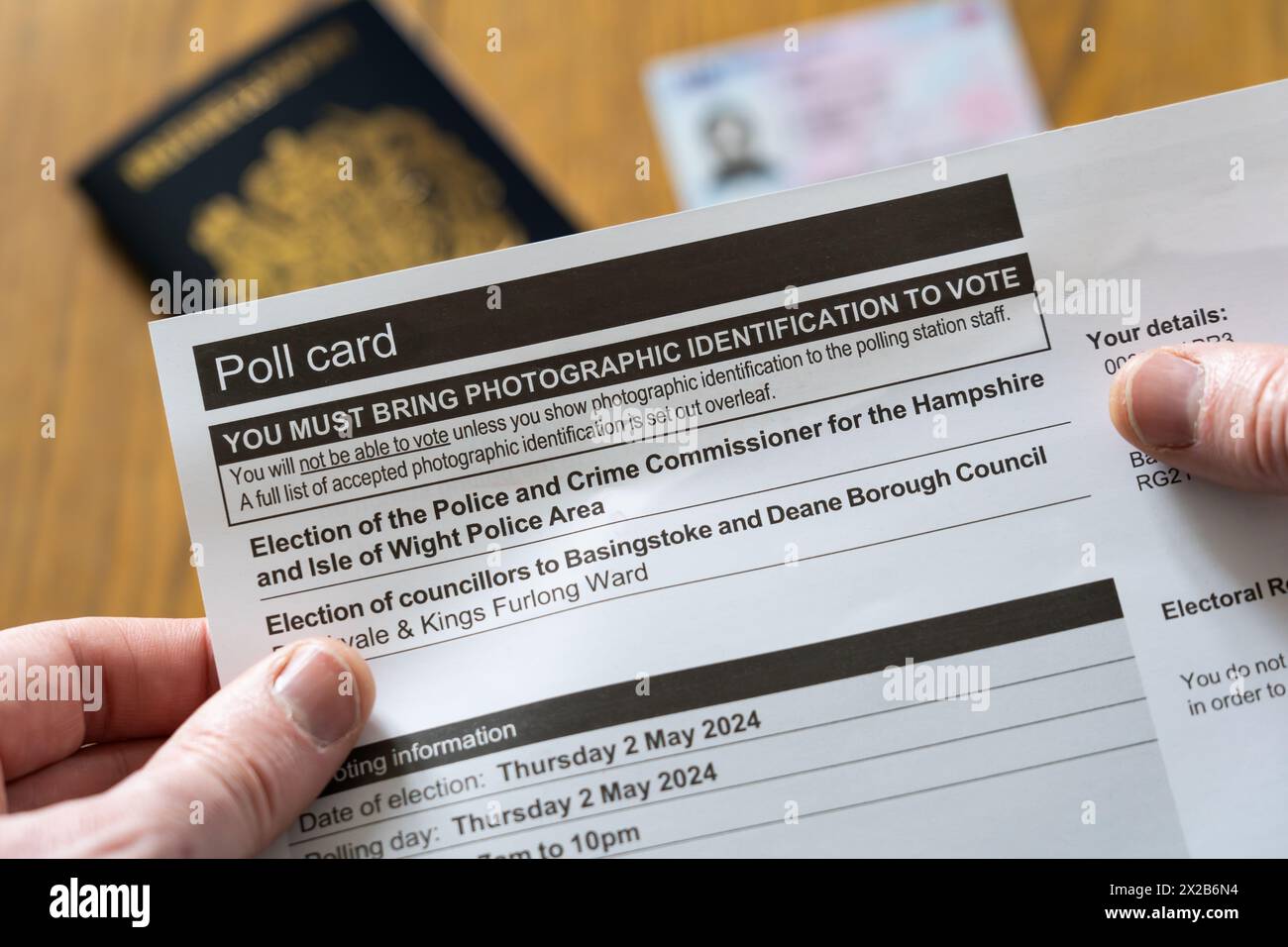 Le mani di un uomo in possesso di una carta di sondaggio per le elezioni locali in Inghilterra nel maggio 2024, con un requisito dichiarato per portare dietro un documento d'identità fotografico e un passaporto Foto Stock