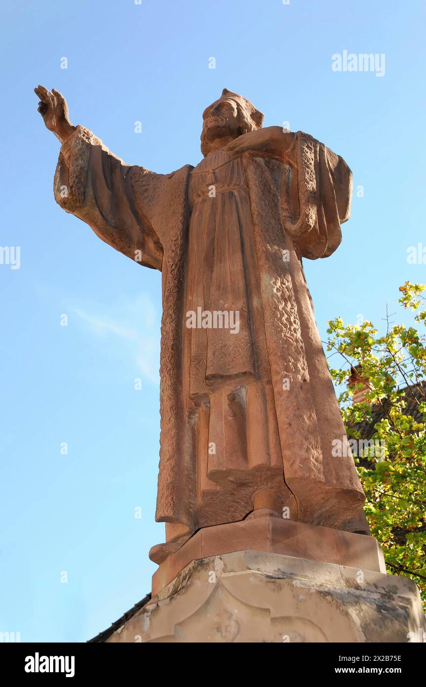 Kaysersberg, strada dei vini dell'Alsazia, Alsazia, Département Haut-Rhin, Francia, Europa, Statua di una figura religiosa di fronte a un cielo limpido, posa alzata delle mani, Foto Stock