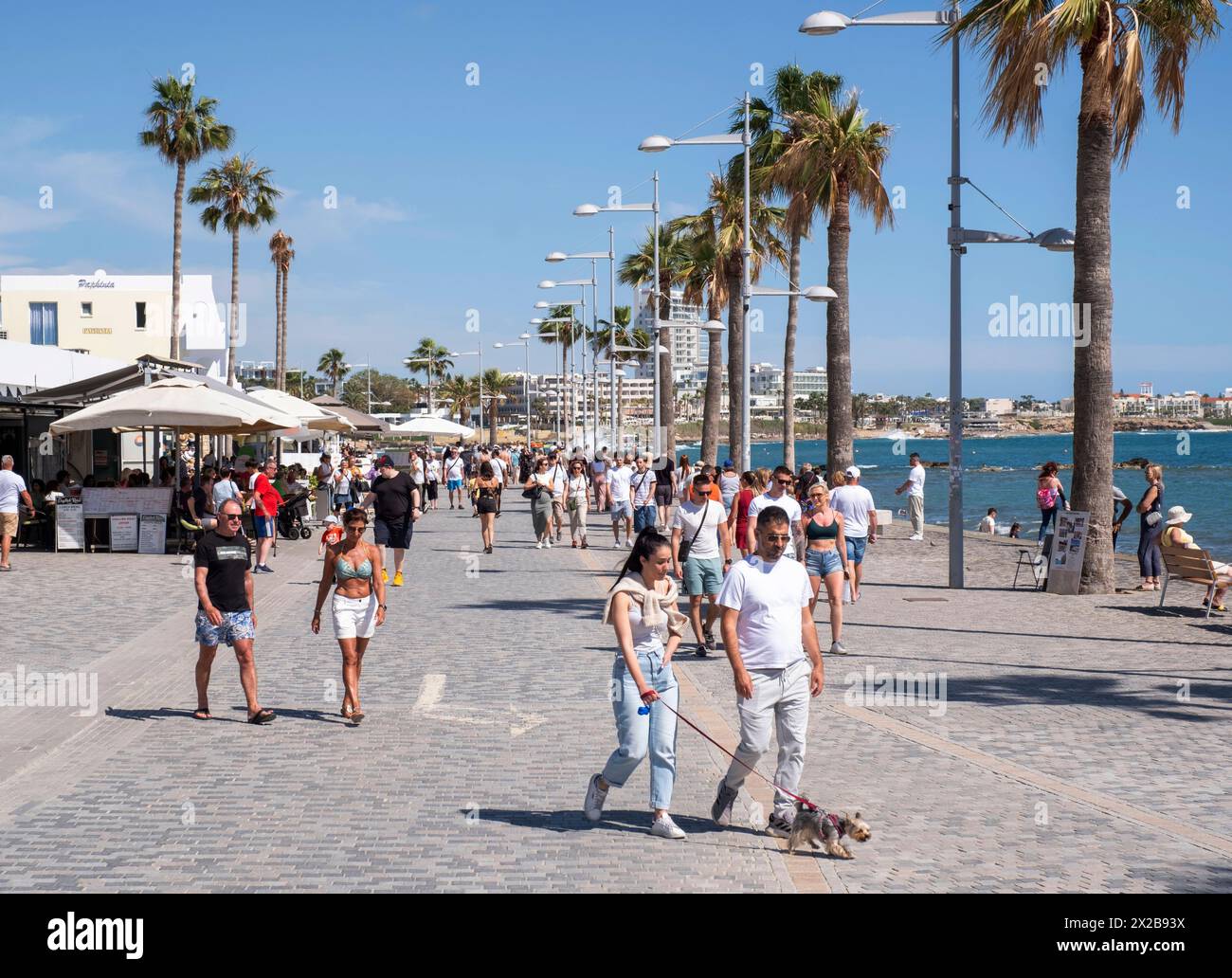 I turisti camminano lungo il lungomare di Poseidonos Avenue, Paphos, Cipro. Foto Stock