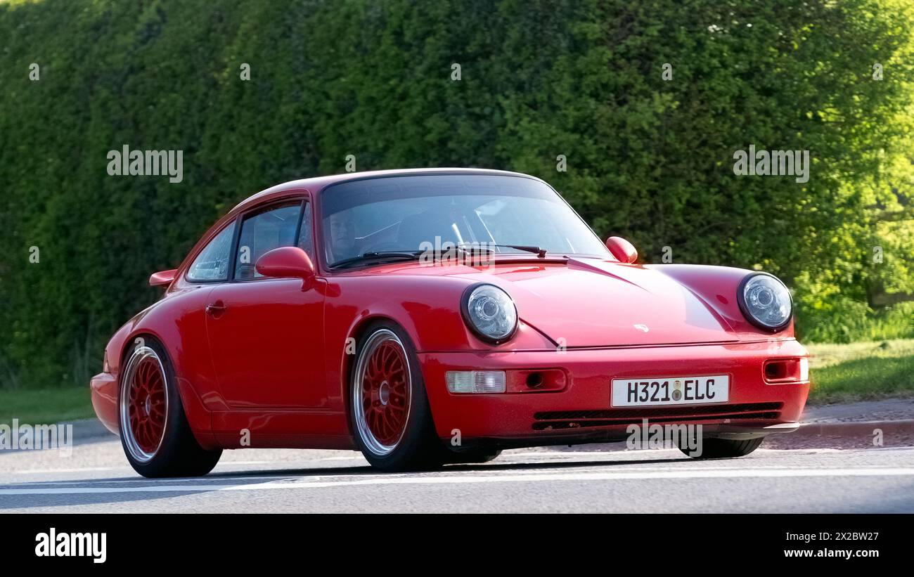 Bicester, UK- 21 aprile 2024: 1990 Porsche 911 Carrera 2 Coupé, rossa, che guida su una strada britannica Foto Stock
