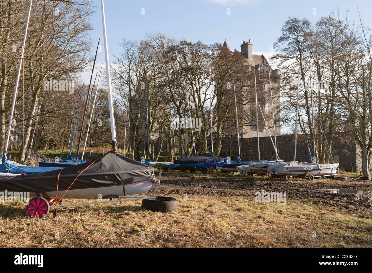 Barche a vela parcheggiate vicino alle Dunecht Estate Gatehouse Towers presso il Loch of Skene in primavera Foto Stock