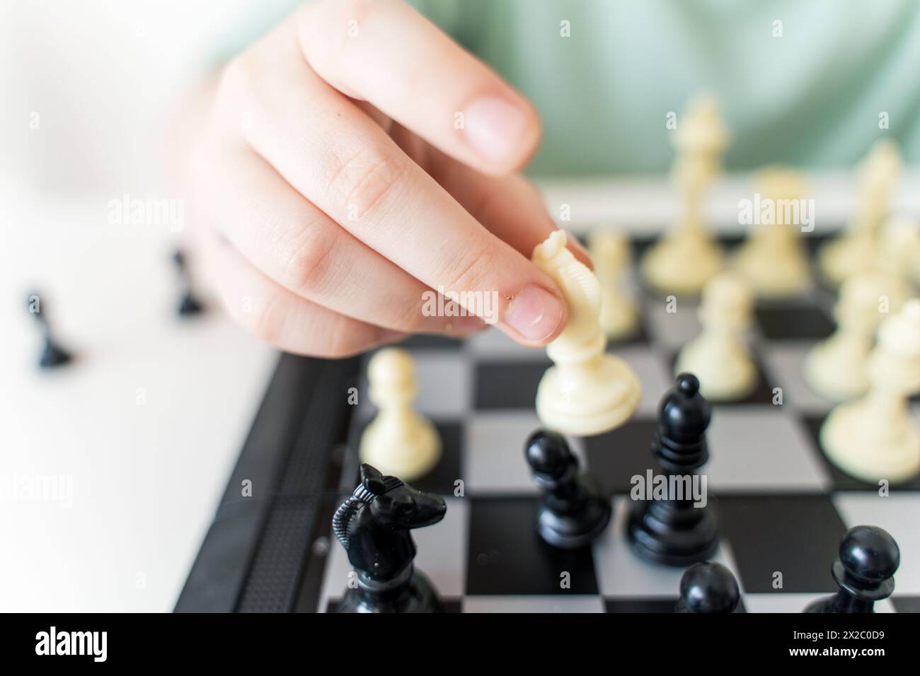 La mano di un bambino riorganizza un pezzo di scacchi su una scacchiera. Primo piano. Punto focale selezionato. Foto di alta qualità Foto Stock