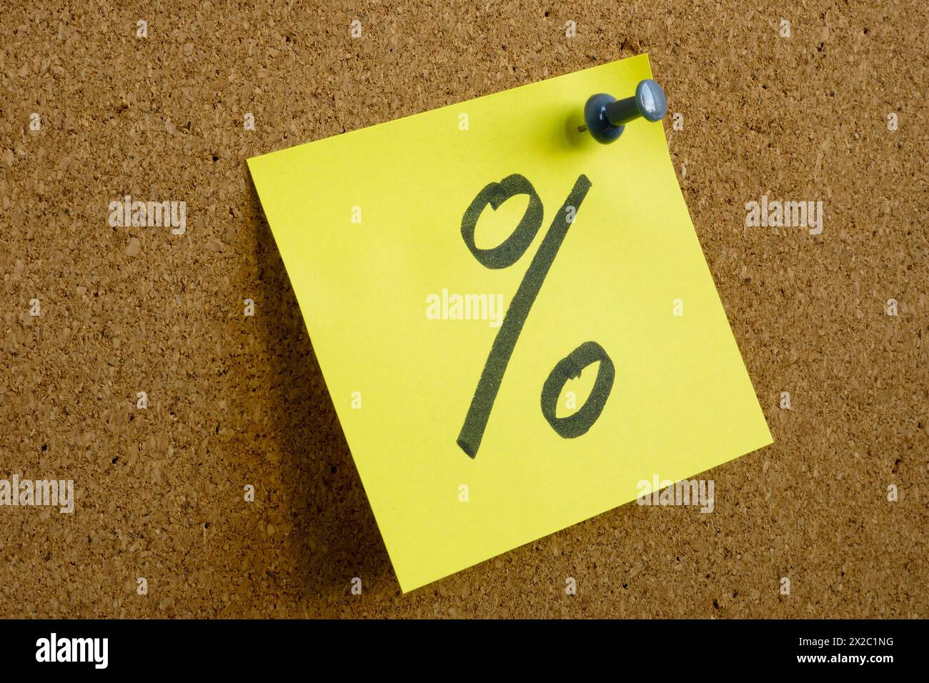 Una nota con un segno di percentuale come simbolo del profitto è fissata a un Consiglio d'amministrazione. Foto Stock