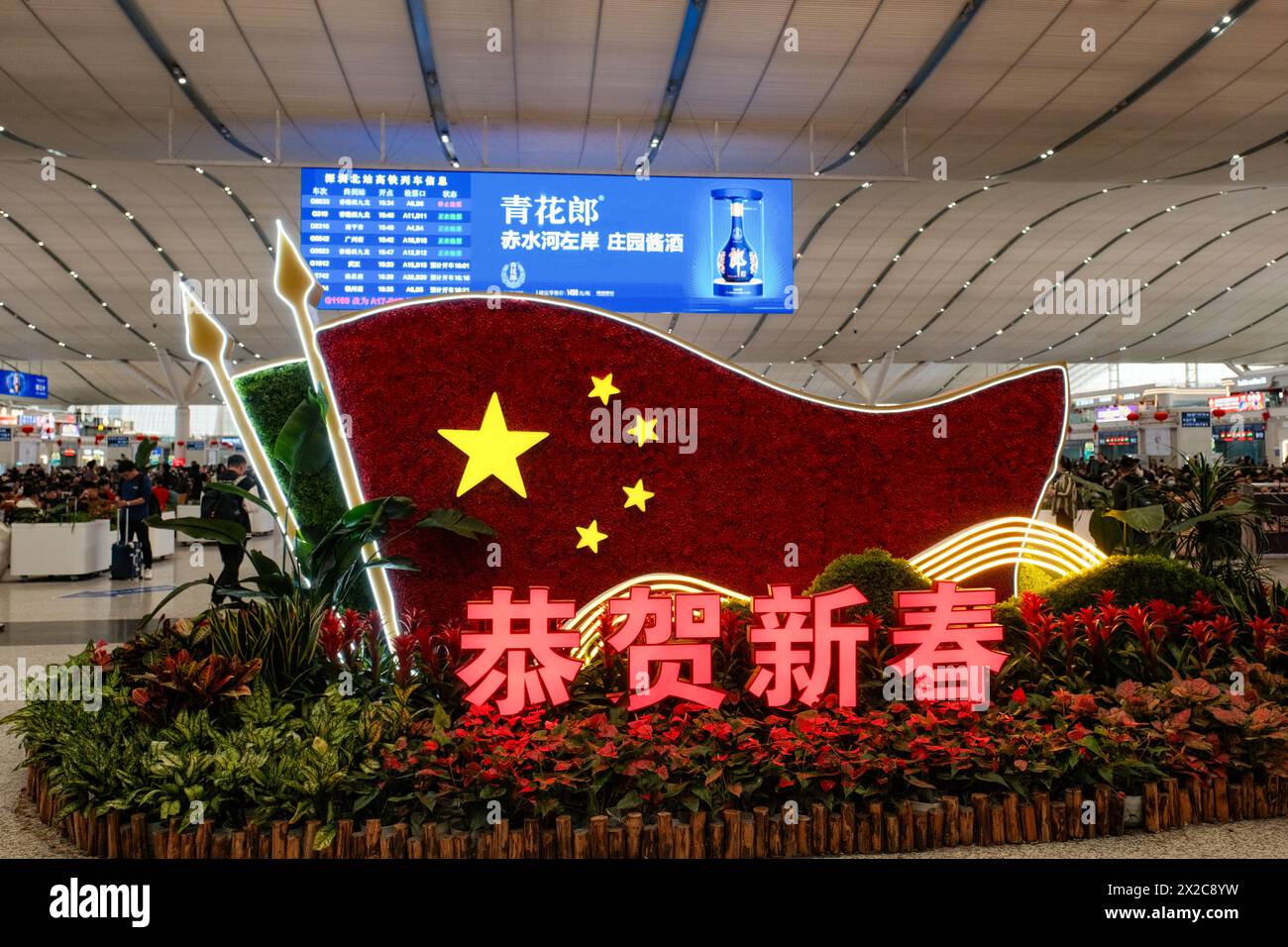 Un'esposizione patriottica adorna la stazione ferroviaria di Guangzhou con i maestosi colori della bandiera cinese, simboleggiando l'orgoglio nazionale e l'unità in mezzo al trambusto Foto Stock