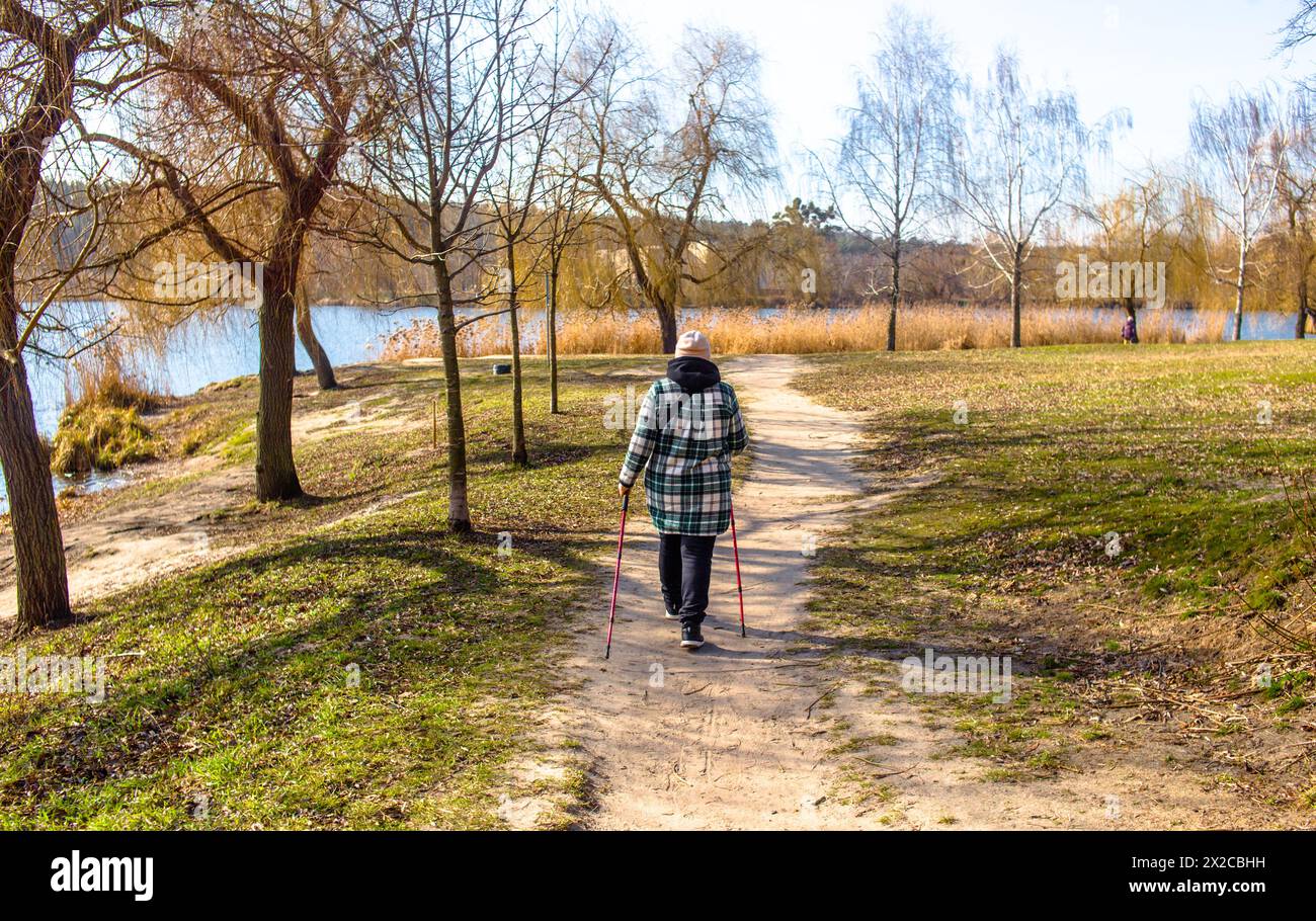 Donna norvegese che cammina accanto al lago Foto Stock