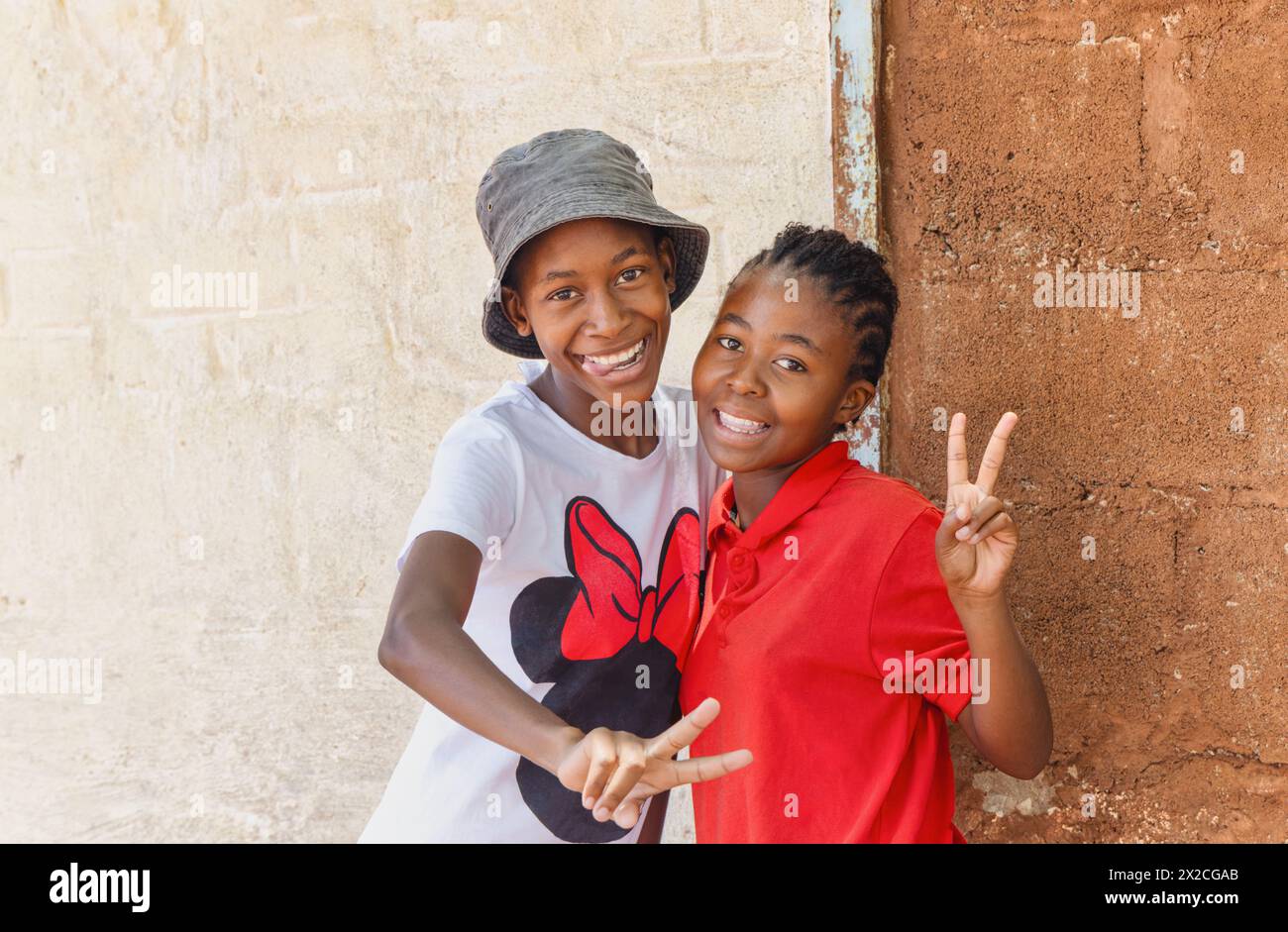 sorridendo ragazze africane giocherellone all'aperto di fronte alla casa in un villaggio Foto Stock