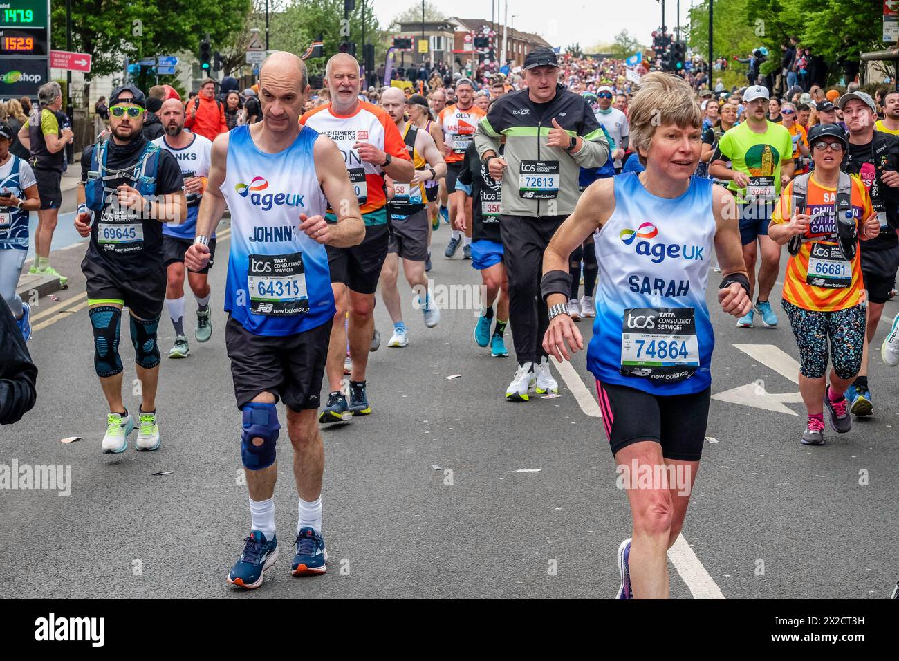 Maratona di Londra 2024: Coppia matura che corre in aiuto di Age UK beneficenza sulla rotta della 44a Maratona di Londra. Foto Stock