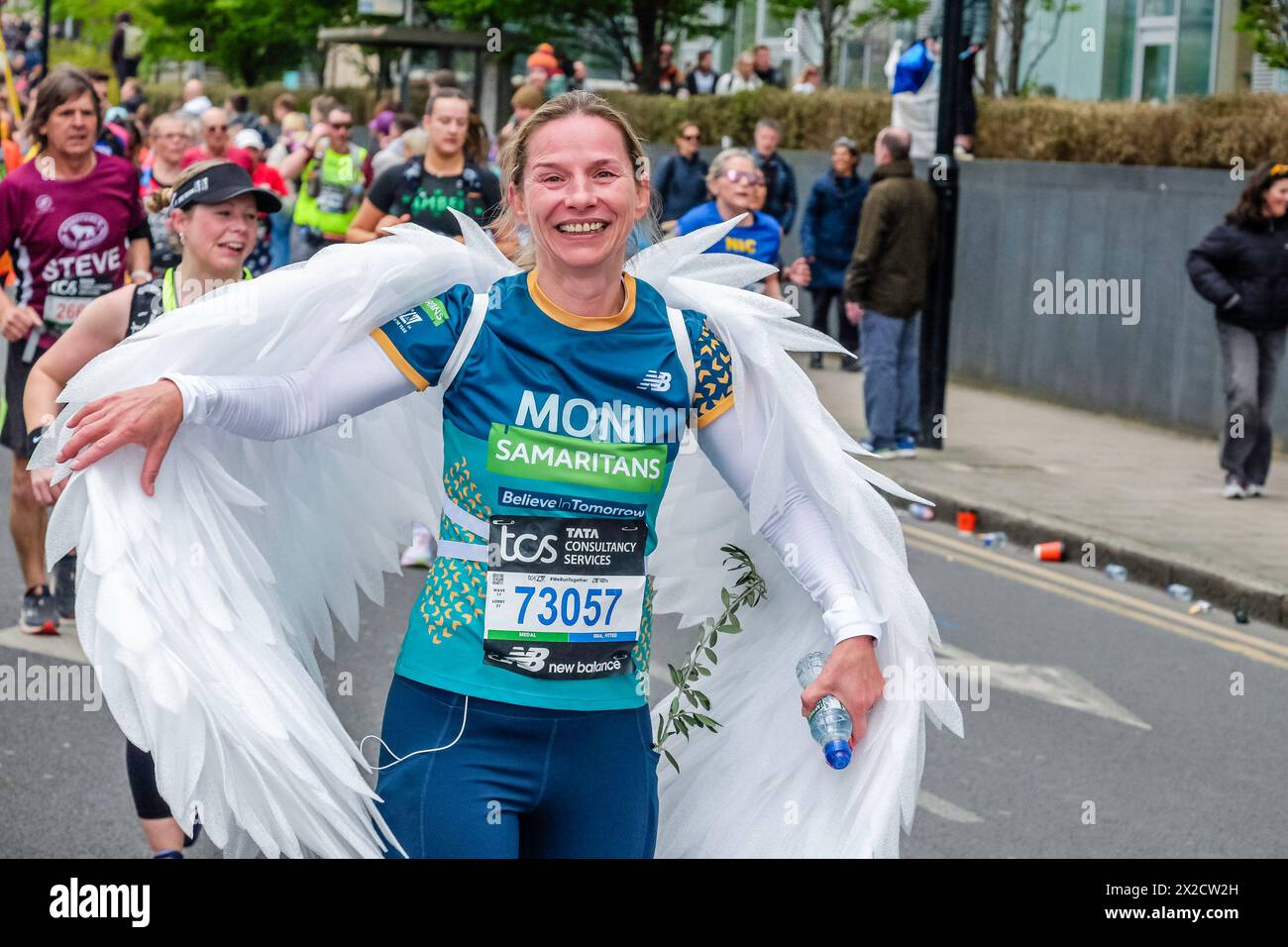 Maratona di Londra 2024: Runner per l'organizzazione benefica Samaritans che indossa un costume bianco sulle ali lungo il percorso della Maratona di Londra. Foto Stock