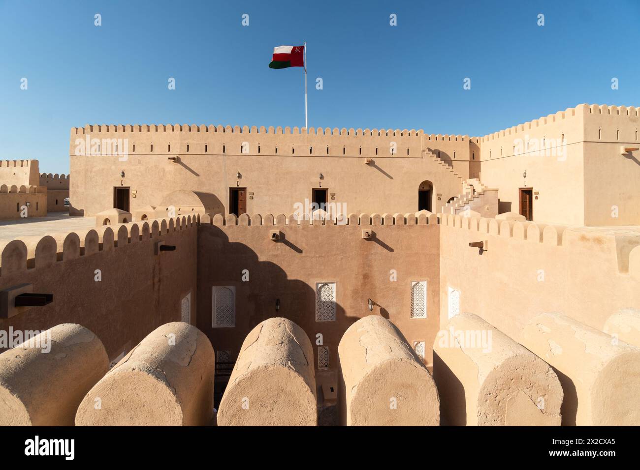 Rustaq, Oman - 14 febbraio 2023: La bandiera nazionale dell'Oman vola all'interno del castello e forte di al Hazm che risale al 1708 nella penisola araba. Foto Stock