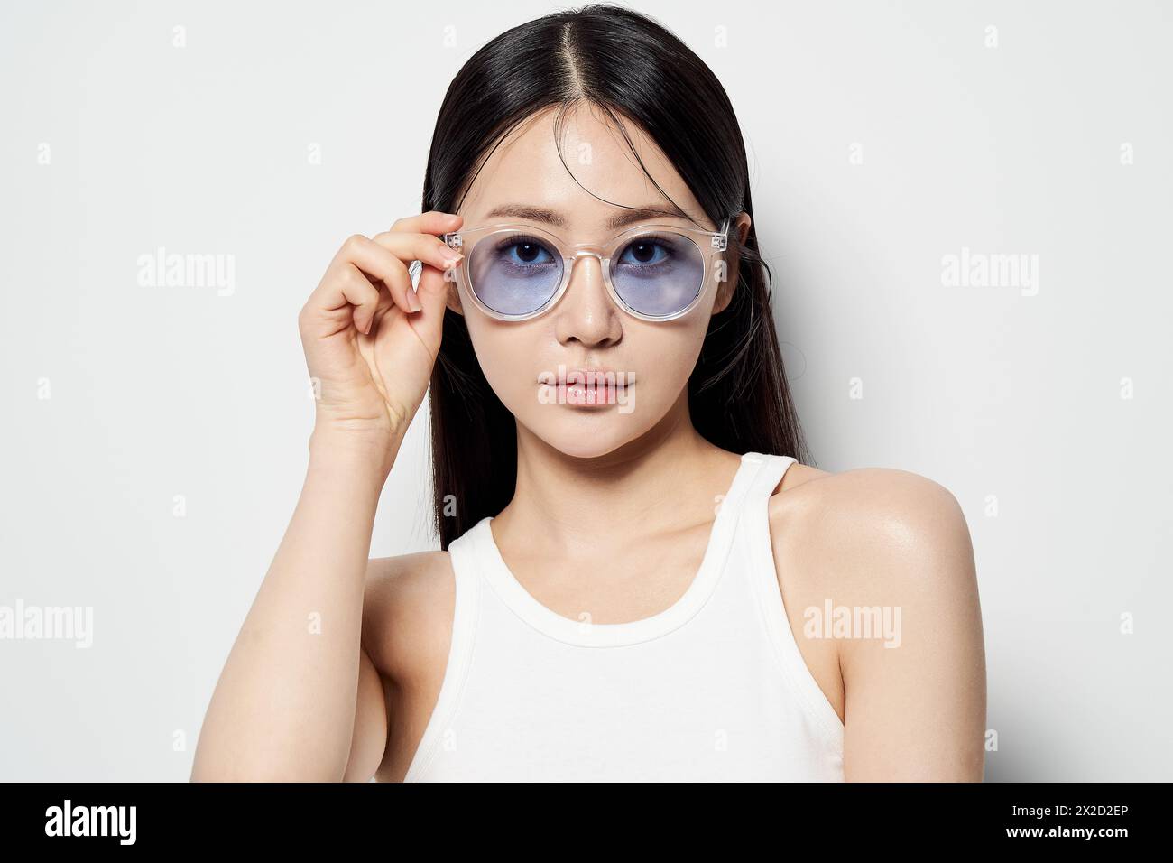 Donna asiatica che ride in occhiali da sole trasparenti Foto Stock