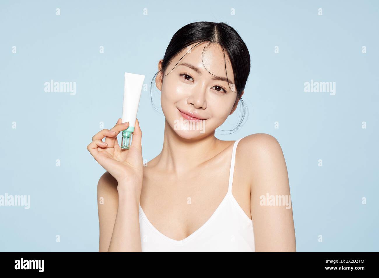 Donna asiatica posa con White Eye Cream Foto Stock