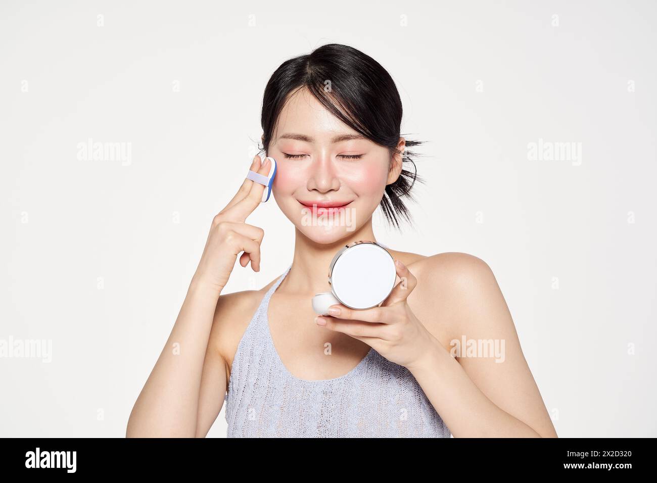 Donna asiatica che mette i fatti del cuscino sul suo viso Foto Stock