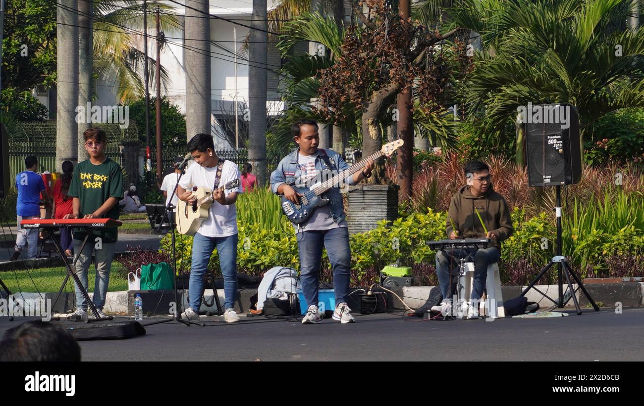 Un gruppo di adolescenti che suonano strumenti musicali e cantano canzoni per intrattenere i visitatori al Car Free Day Malang Foto Stock