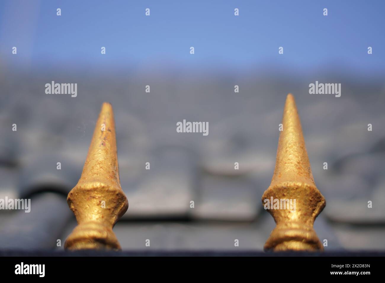 Due oggetti dorati di forma triangolare con estremità affilate e uno sfondo blu sfocato del cielo Foto Stock