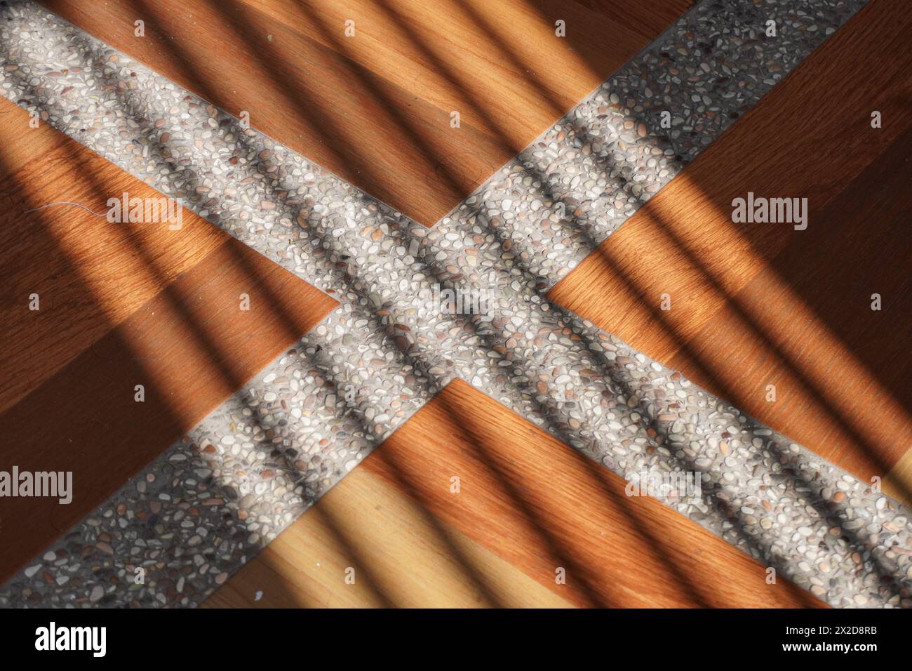 Ombre di linee oblique che colpiscono la superficie delle piastrelle marroni con linee bianche nel pomeriggio Foto Stock