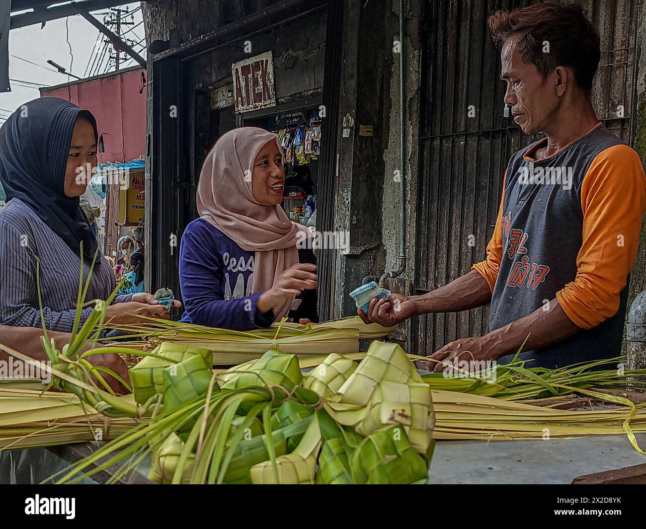 I venditori vendono ketupat per le celebrazioni di Eid al-Fitr a Bogor, Giava Occidentale, Indonesia, l'8 aprile 2024 Foto Stock