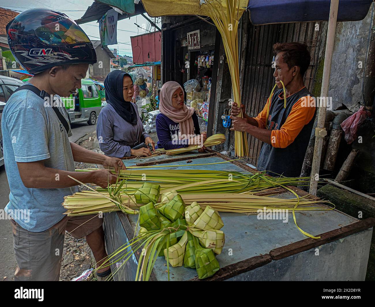 I venditori vendono ketupat per le celebrazioni di Eid al-Fitr a Bogor, Giava Occidentale, Indonesia, l'8 aprile 2024 Foto Stock