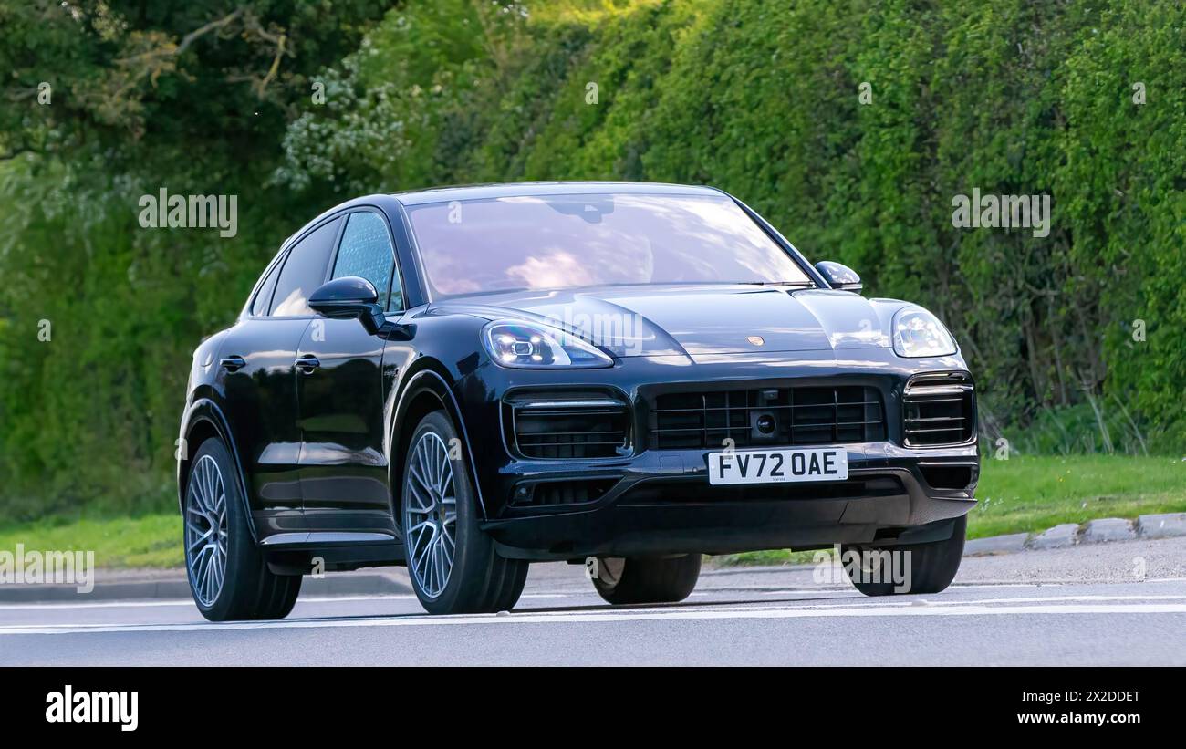 Bicester, Regno Unito - 21 aprile 2024: 2022 auto d'epoca elettrica ibrida Porsche Cayenne che guida su una strada britannica Foto Stock