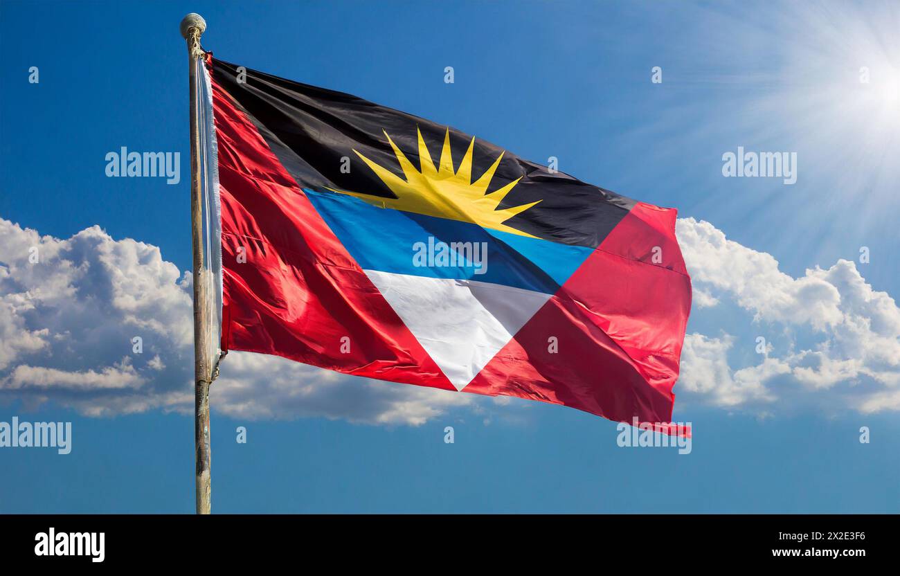 Die Fahne von Antigua flattert im Wind, isoliert, gegen den blauen Himmel Foto Stock
