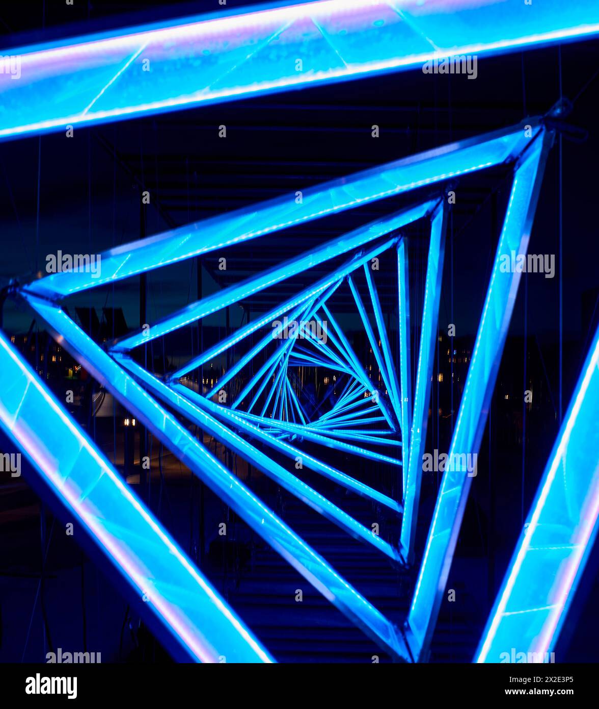 I dettagli di un tunnel azzurro triangolare luminoso trasmettono un concetto di realtà distorta o distorta. Primo piano di un passaggio a forma di triangolo azzurro Foto Stock