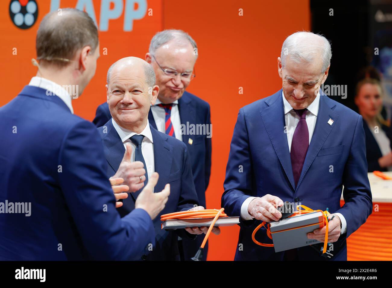 Hannover, Germania. 22 aprile 2024. Matthias Lapp (l-r), CEO di Lapp, presenta in dono il cancelliere tedesco Olaf Scholz (SPD) e Jonas Gahr Støre, primo ministro norvegese, con un cavo di prolunga. Credito: Michael Matthey/dpa/Alamy Live News Foto Stock