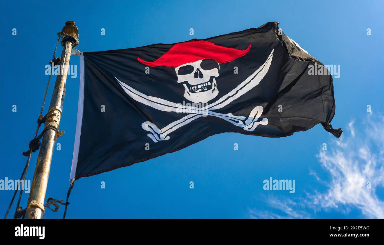 Die Piratenflagge flattert im Wind, isoliert, gegen den blauen Himmel Foto Stock