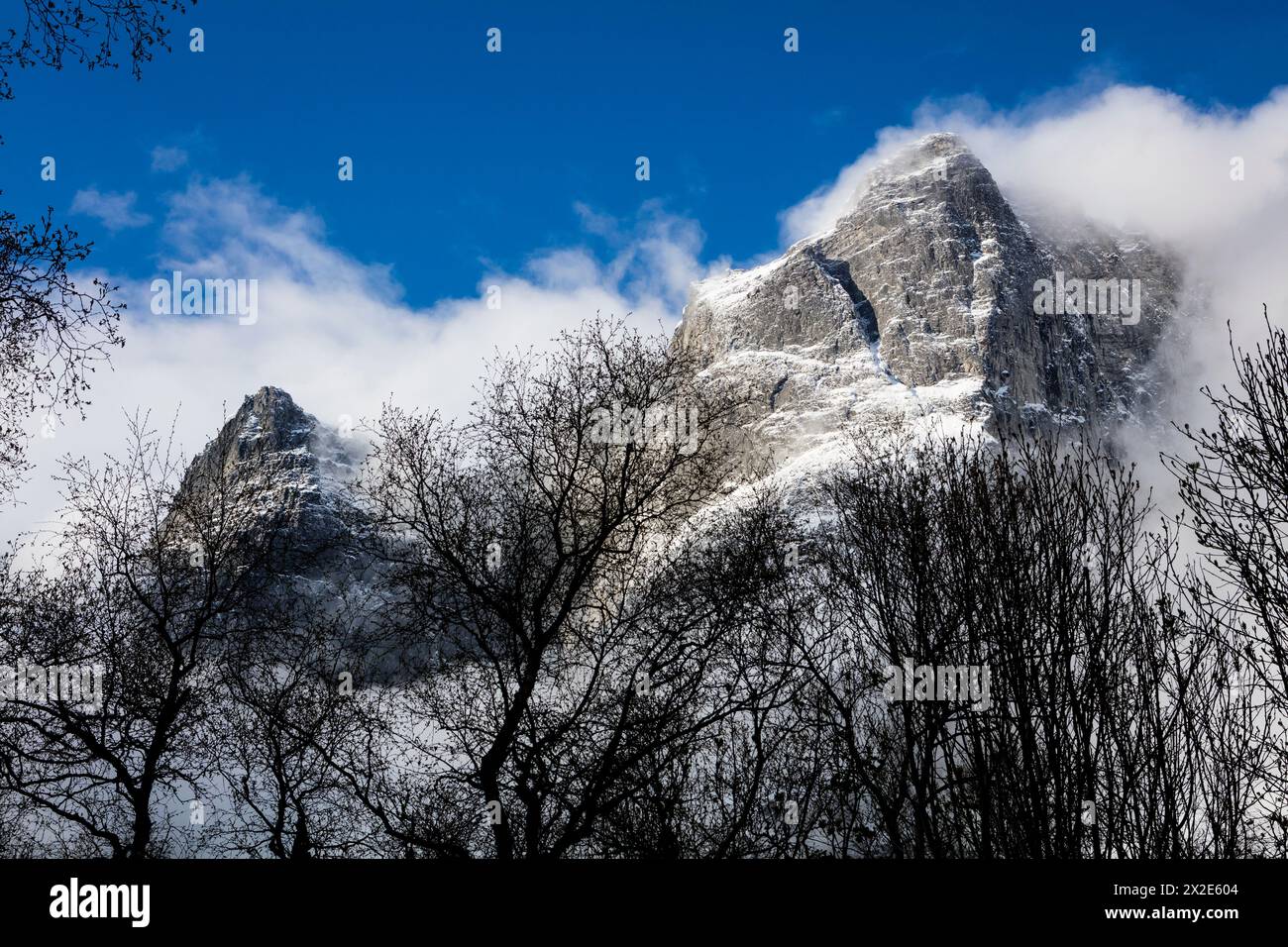 Paesaggio montano con nebbia intorno alle vette Semletind (a sinistra) e Trollryggen (a destra) nella valle Romsdalen, Rauma kommune, Møre og Romsdal, Norvegia Foto Stock