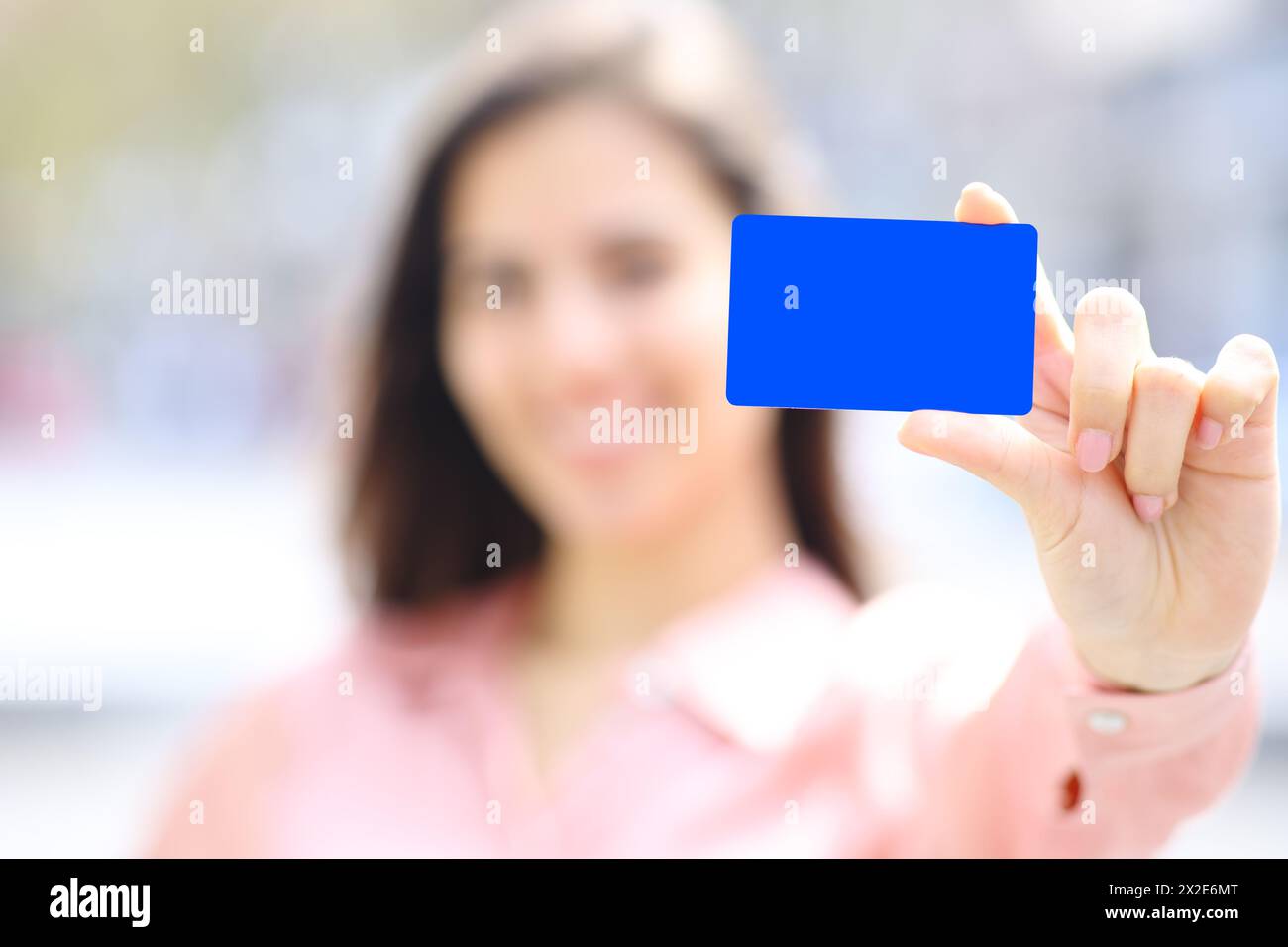 Primo piano ritratto di una donna elegante che mostra un modello di carta di credito nera per strada Foto Stock