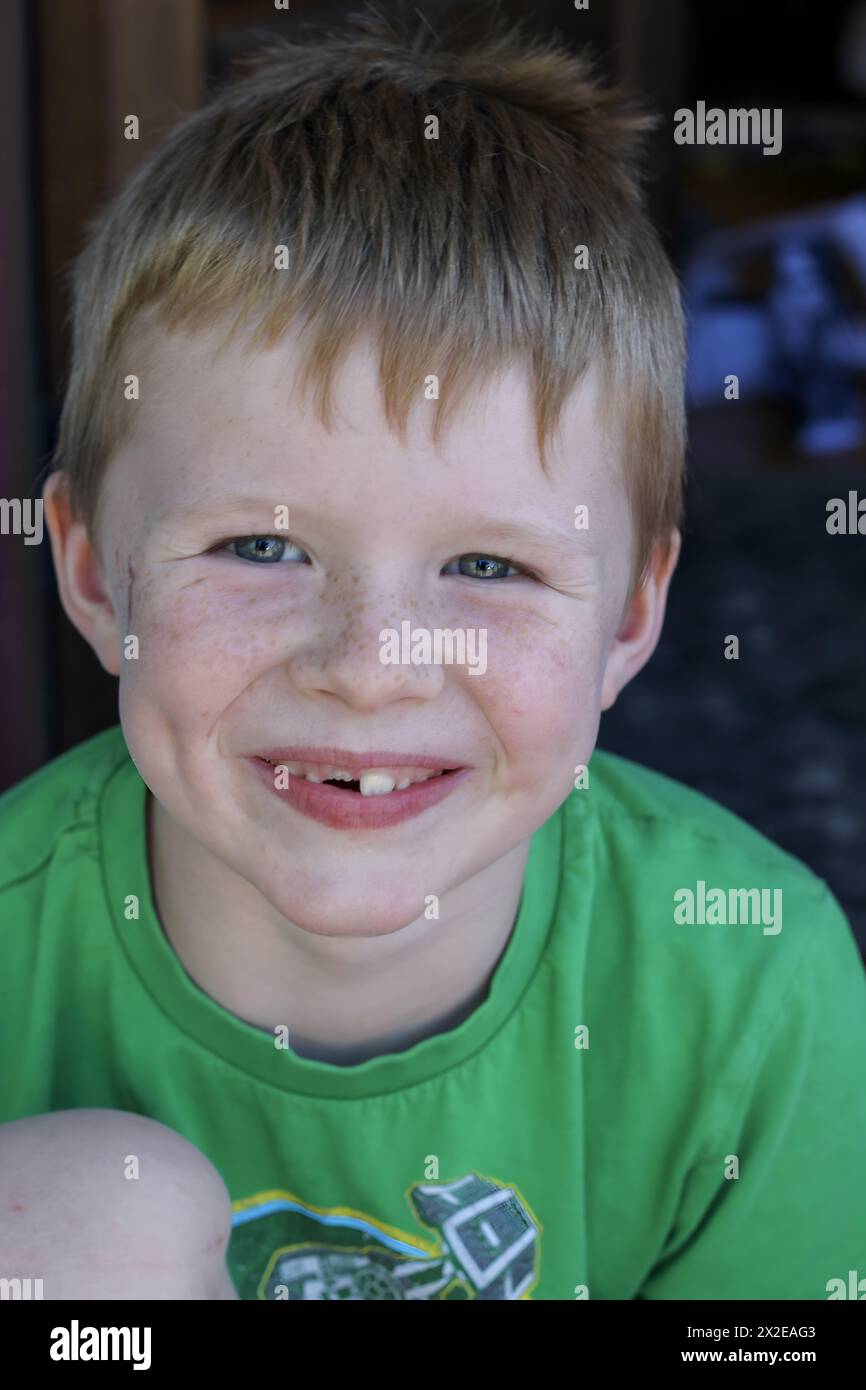 Allegro ragazzo con un sorriso brillante e senza denti Foto Stock