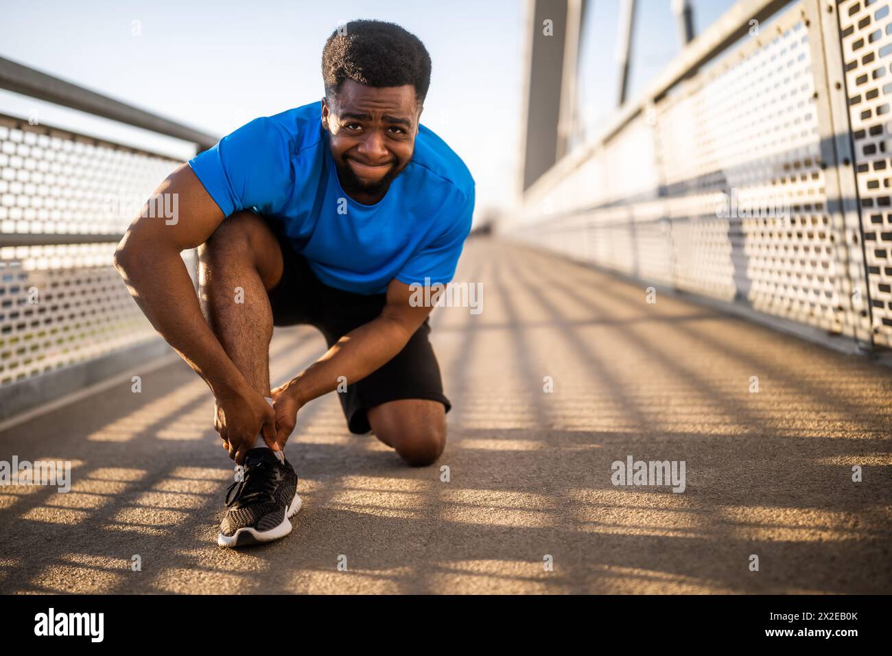 Il giovane afroamericano è ferito mentre fa jogging. Si è distorto la caviglia. Foto Stock