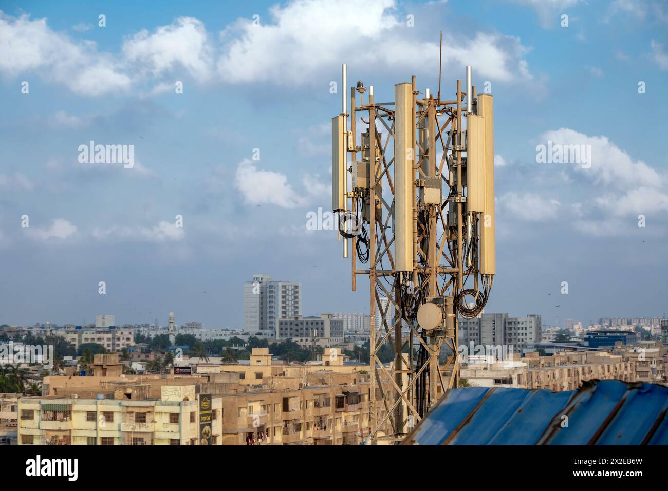 Torre di telecomunicazione con antenna di rete cellulare 5G sullo sfondo della città di Karachi Foto Stock