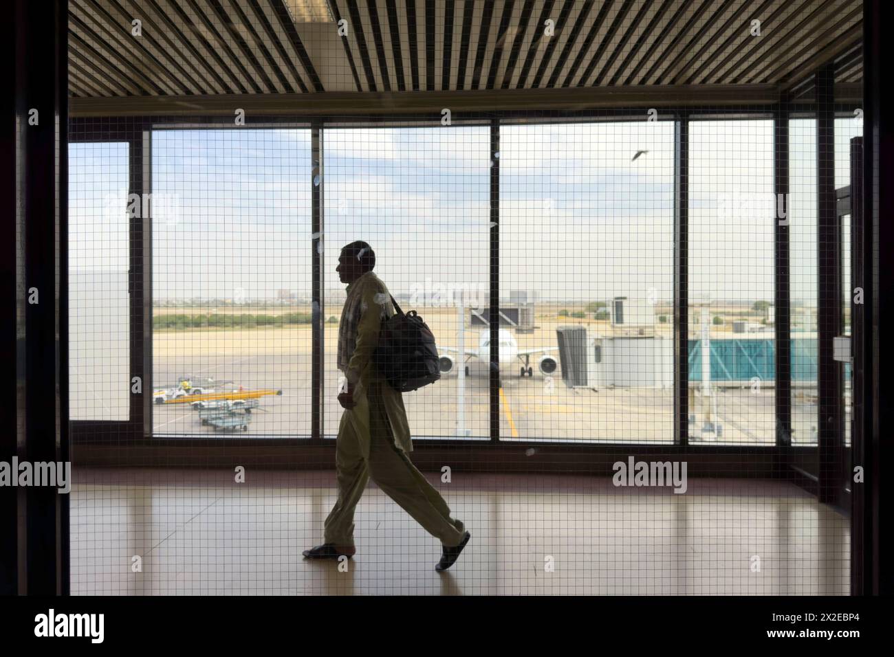 Sala del terminal dell'aeroporto. Silhouette a piedi viaggiatori in aereo. Aeroporto internazionale di Jinnah, Karachi Foto Stock