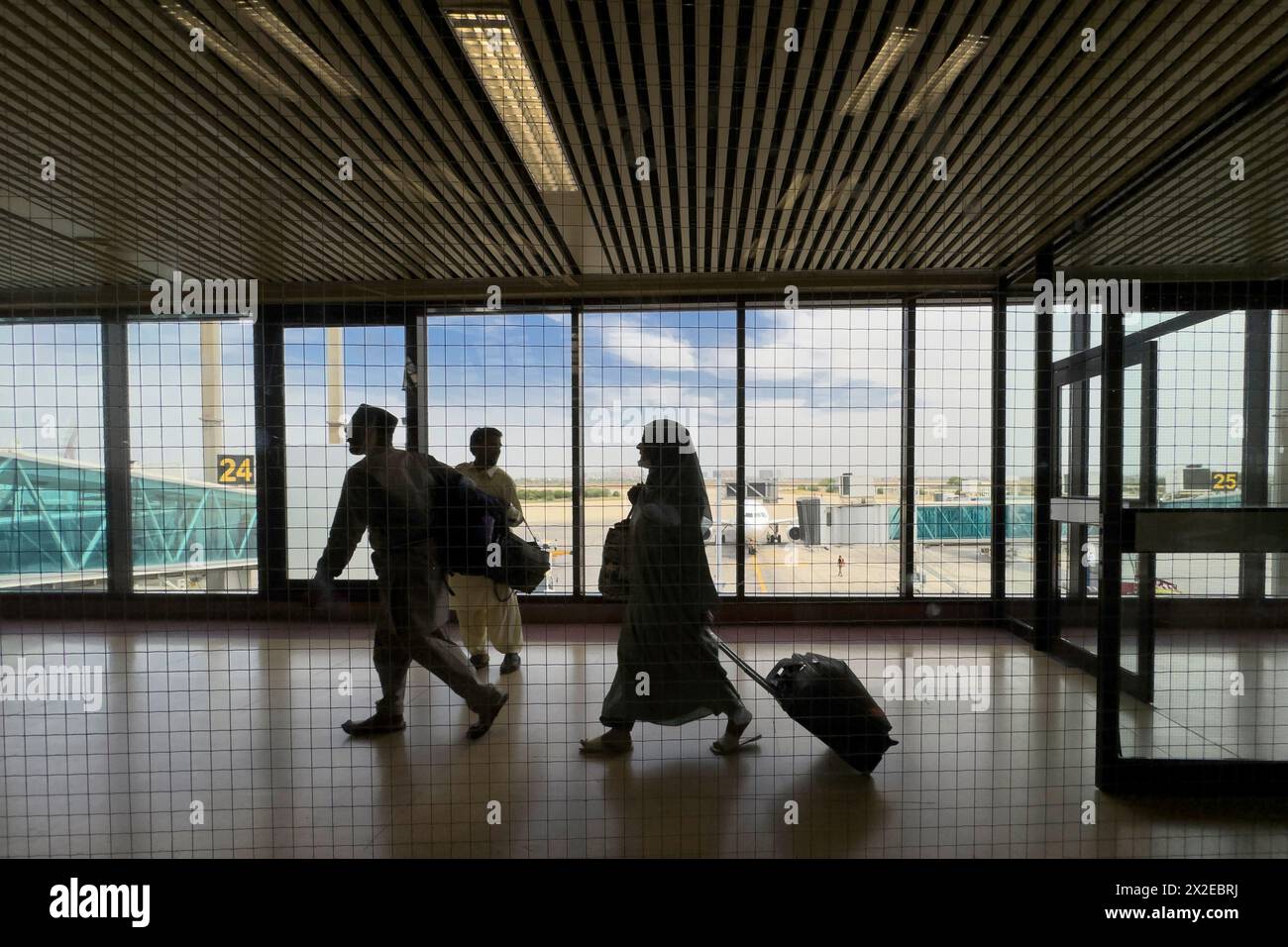 Sala del terminal dell'aeroporto. Silhouette a piedi viaggiatori in aereo. Aeroporto internazionale di Jinnah, Karachi Foto Stock